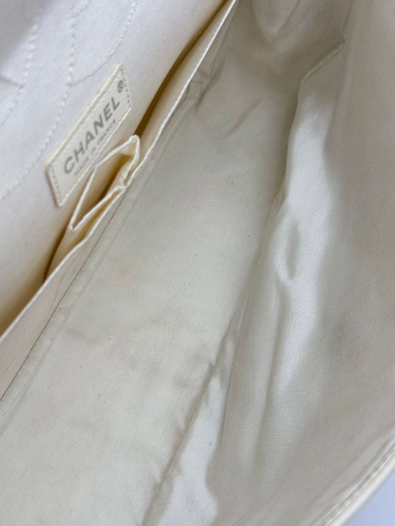 Innenetikett und Futter der CHANEL Double Flap Bag Jumbo in cremefarbenem Leder mit charakteristischem Markenlogo