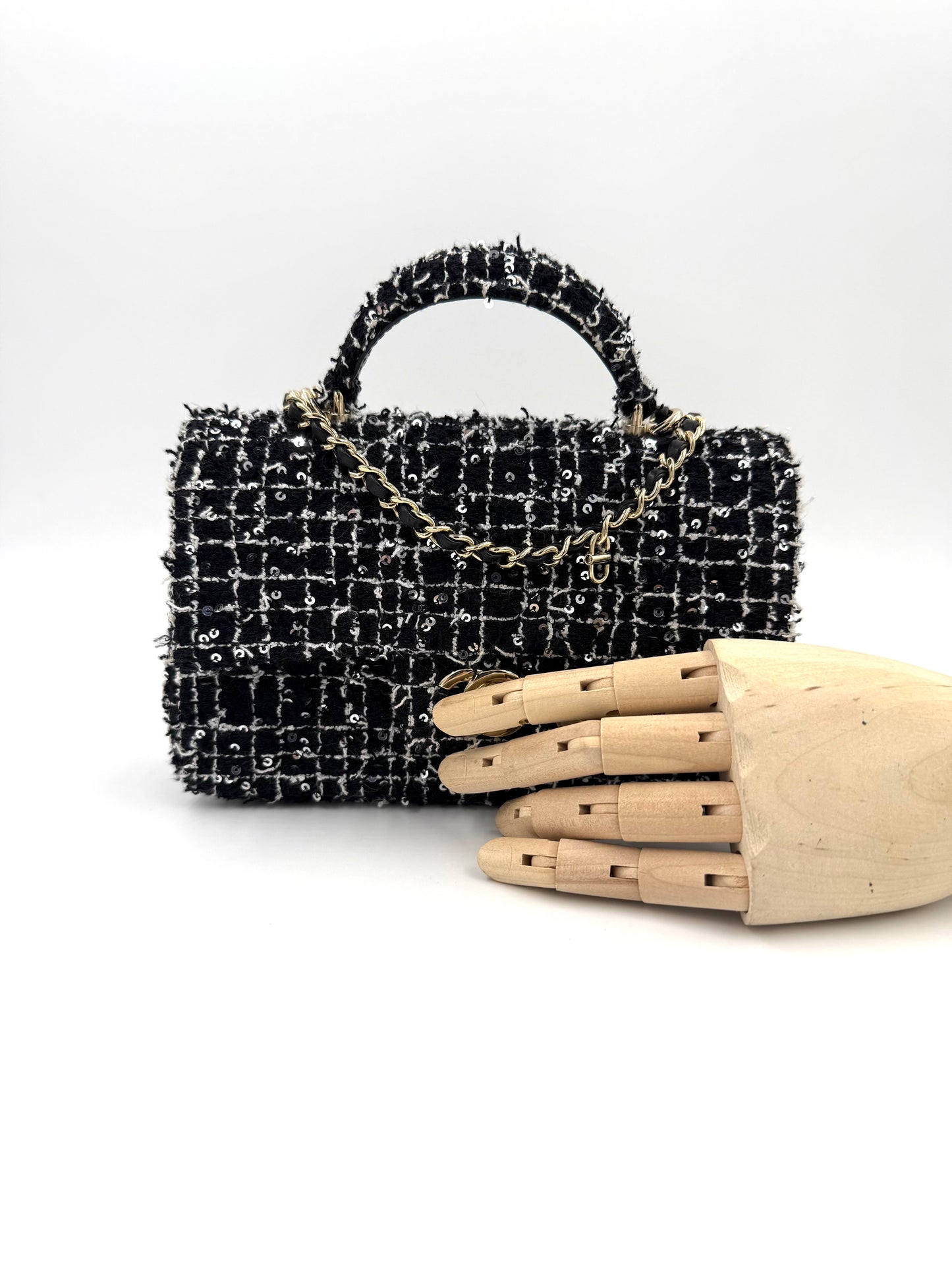 CHANEL Flap Bag Tweed schwarz/weiß GHW elegante Designerhandtasche aus Tweed mit goldfarbener Kette und Holz-Handmodell.