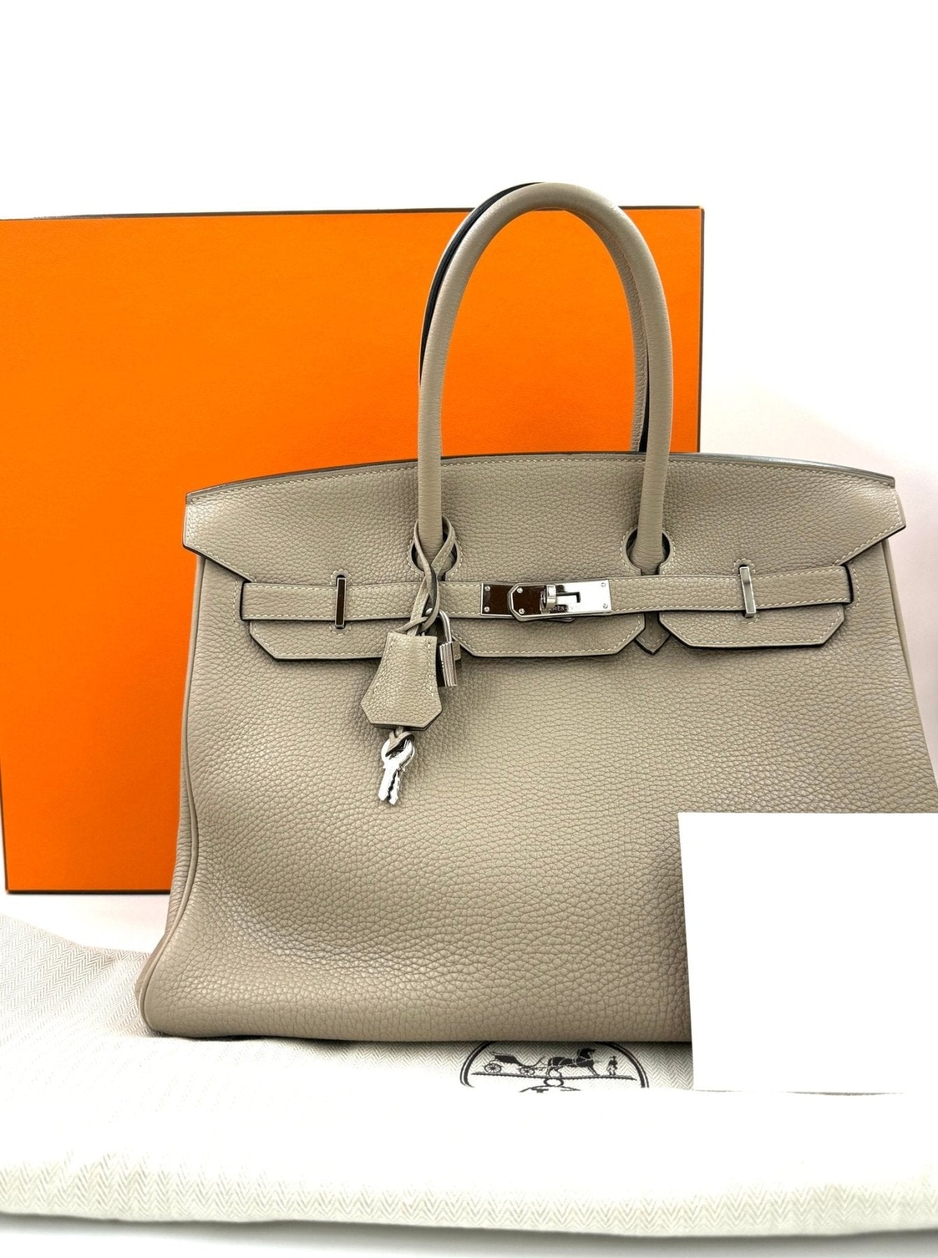 HERMES Birkin 35 Togo Gris Tourterelle Handtasche aus grauem Togoleder mit Palladiumbeschlagen vor orangefarbener Box