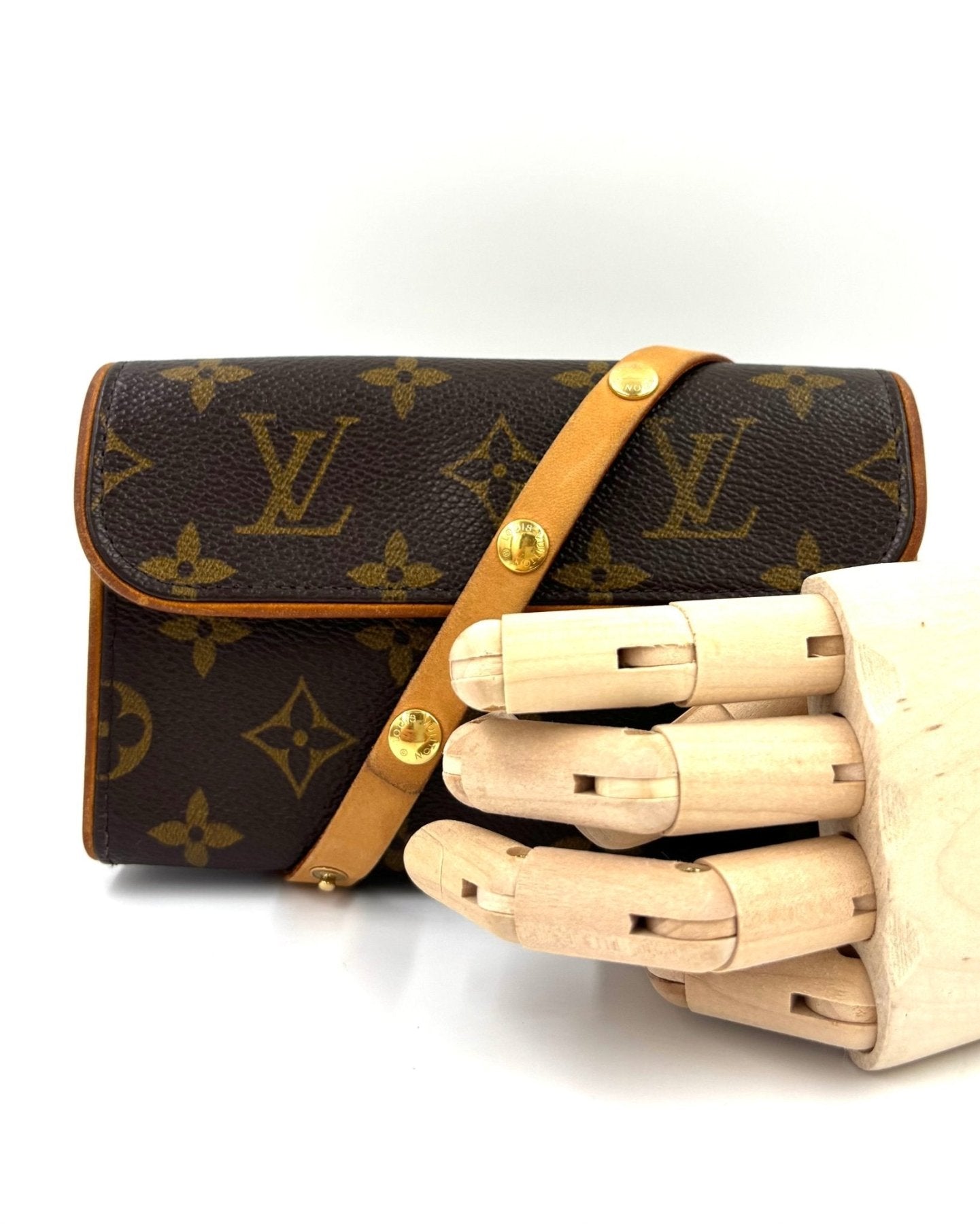 Louis Vuitton Pochette Florentine aus Monogram Canvas mit braunem Lederriemen, fotografiert auf hellem Hintergrund