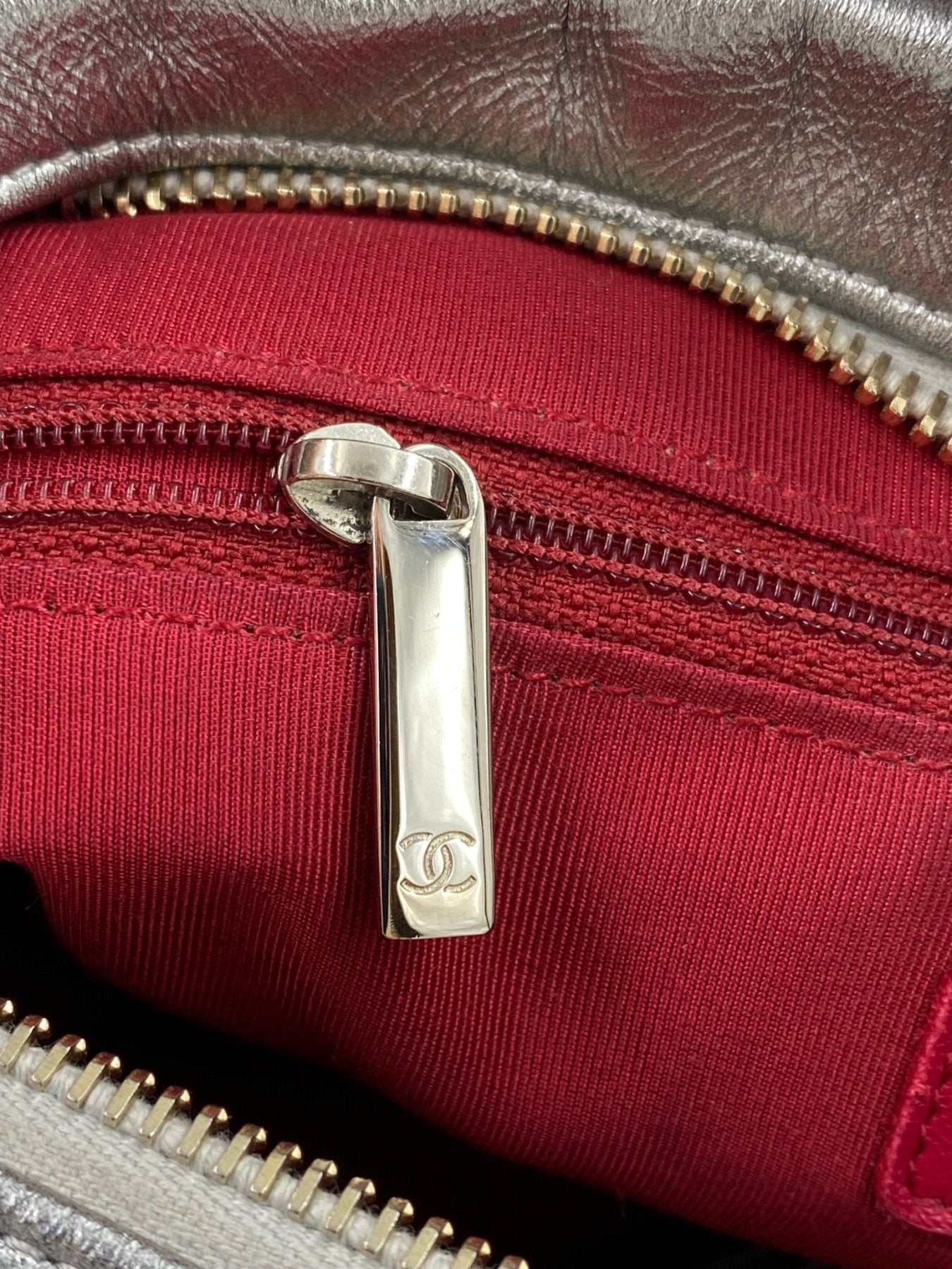 CHANEL Gabrielle Tasche silber Reissverschlussdetail mit rotem Innenfutter und metallenem Zipper in Nahaufnahme