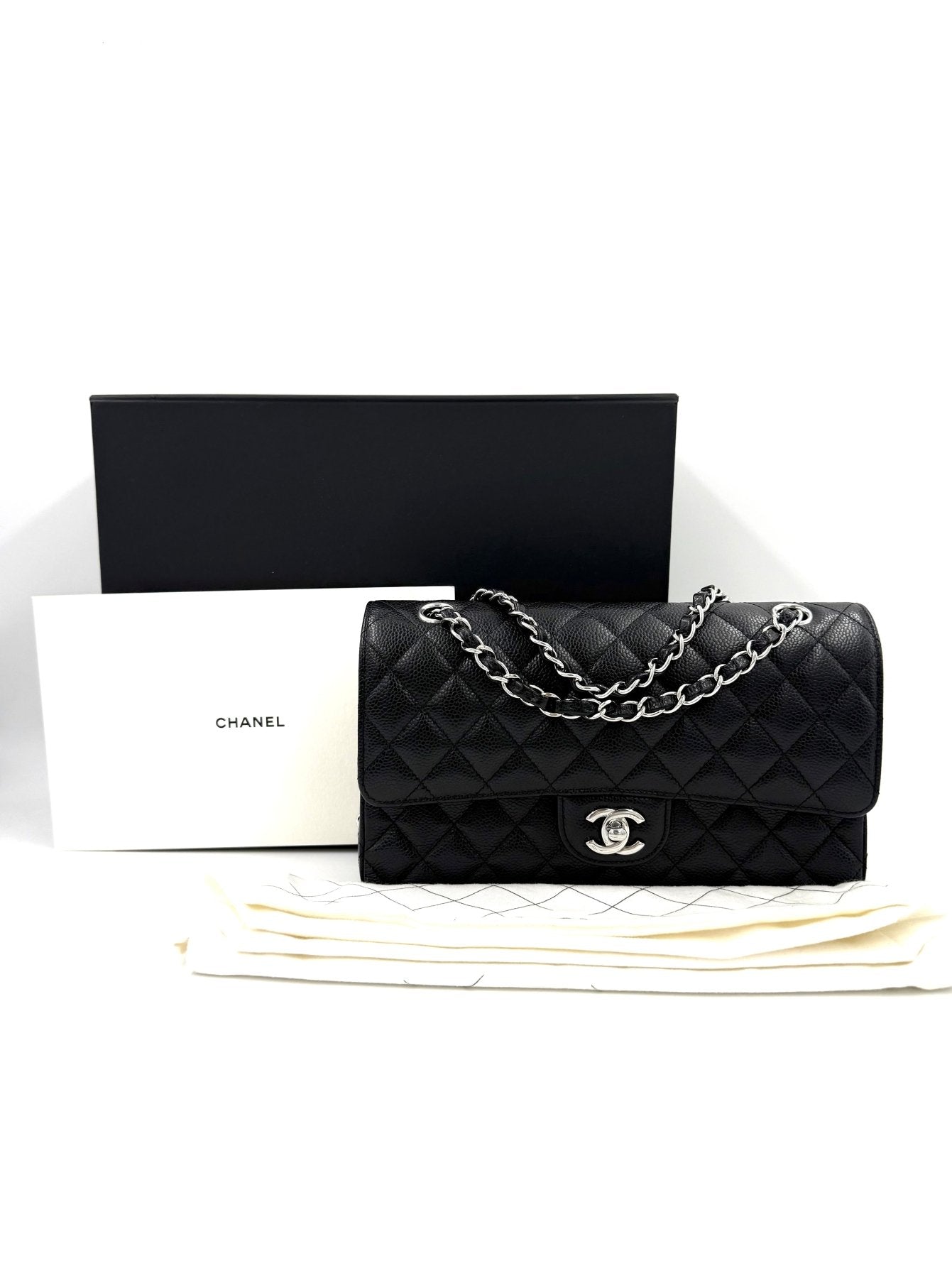 Chanel Timeless Double Flap medium Tasche in schwarzem Caviarleder mit Silberkette und Box auf weissem Hintergrund