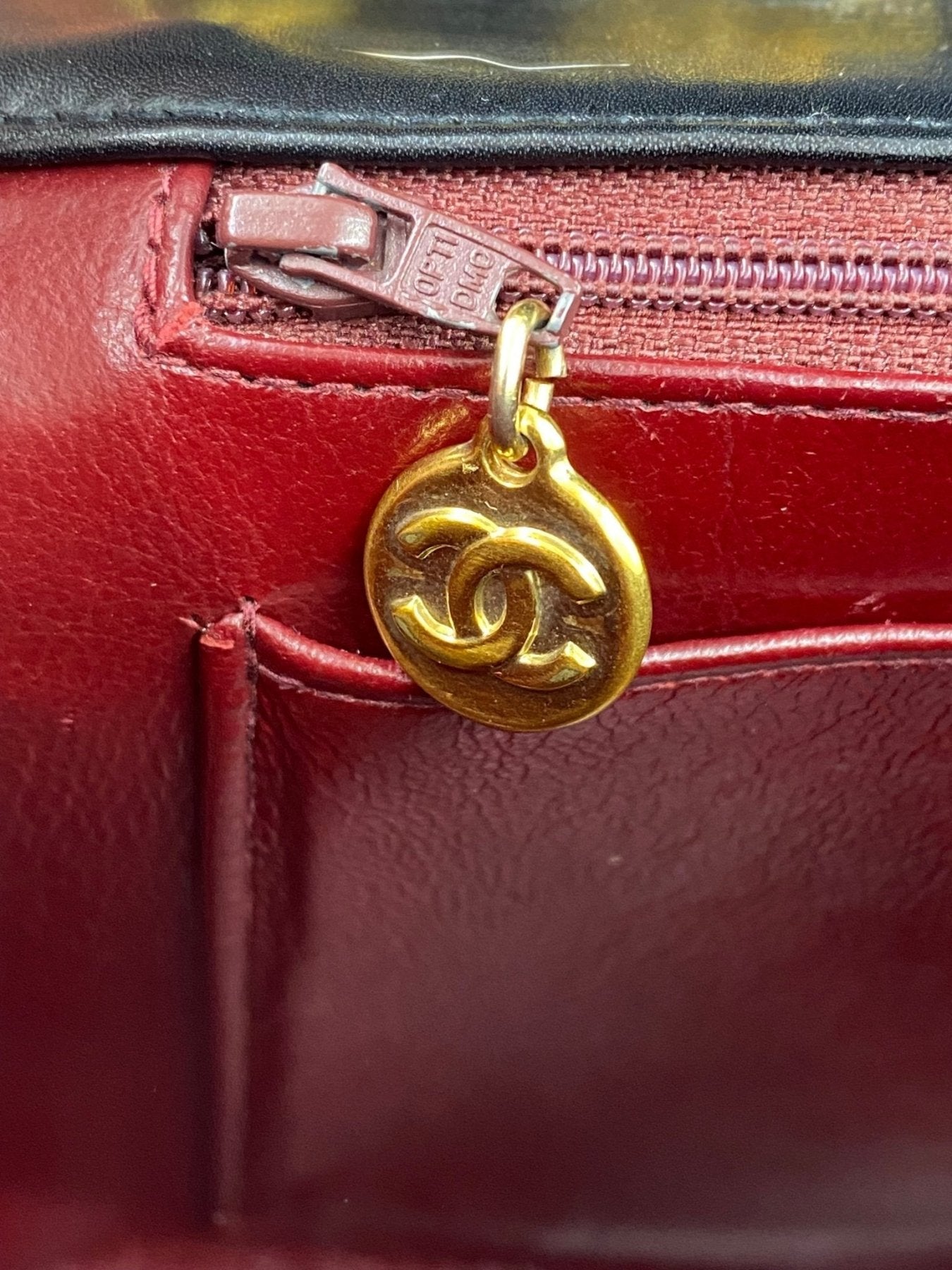 CHANEL Timeless Single Flap Bag Maxi Detailaufnahme des bordeauxroten Innenfutters mit goldenem CC-Reissverschlussanhaenger