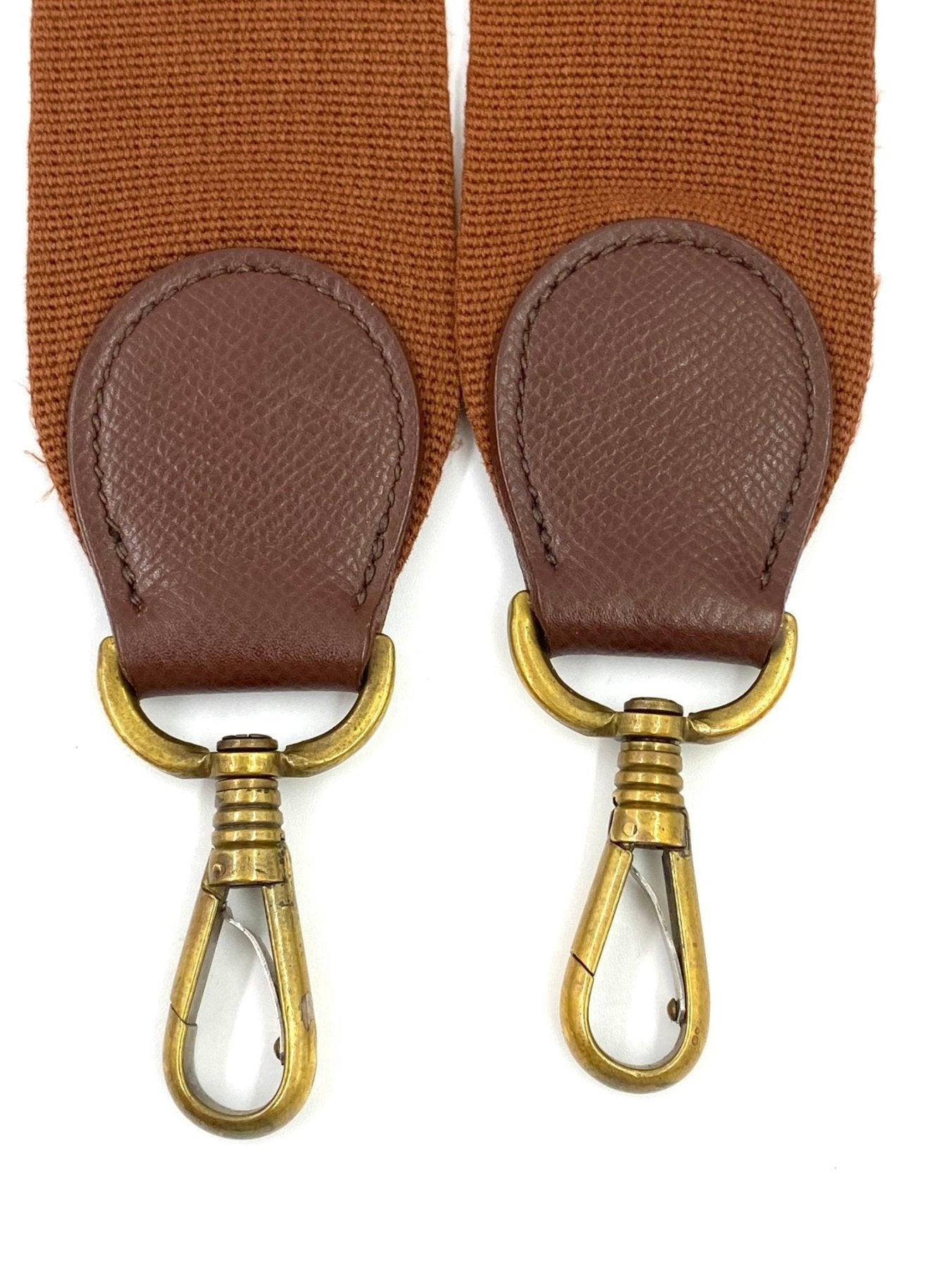 Hermes Evelyne 33 Schulterriemen-Detail mit braunen Lederhalterungen und goldenen Karabinerhaken auf texturiertem Stoff