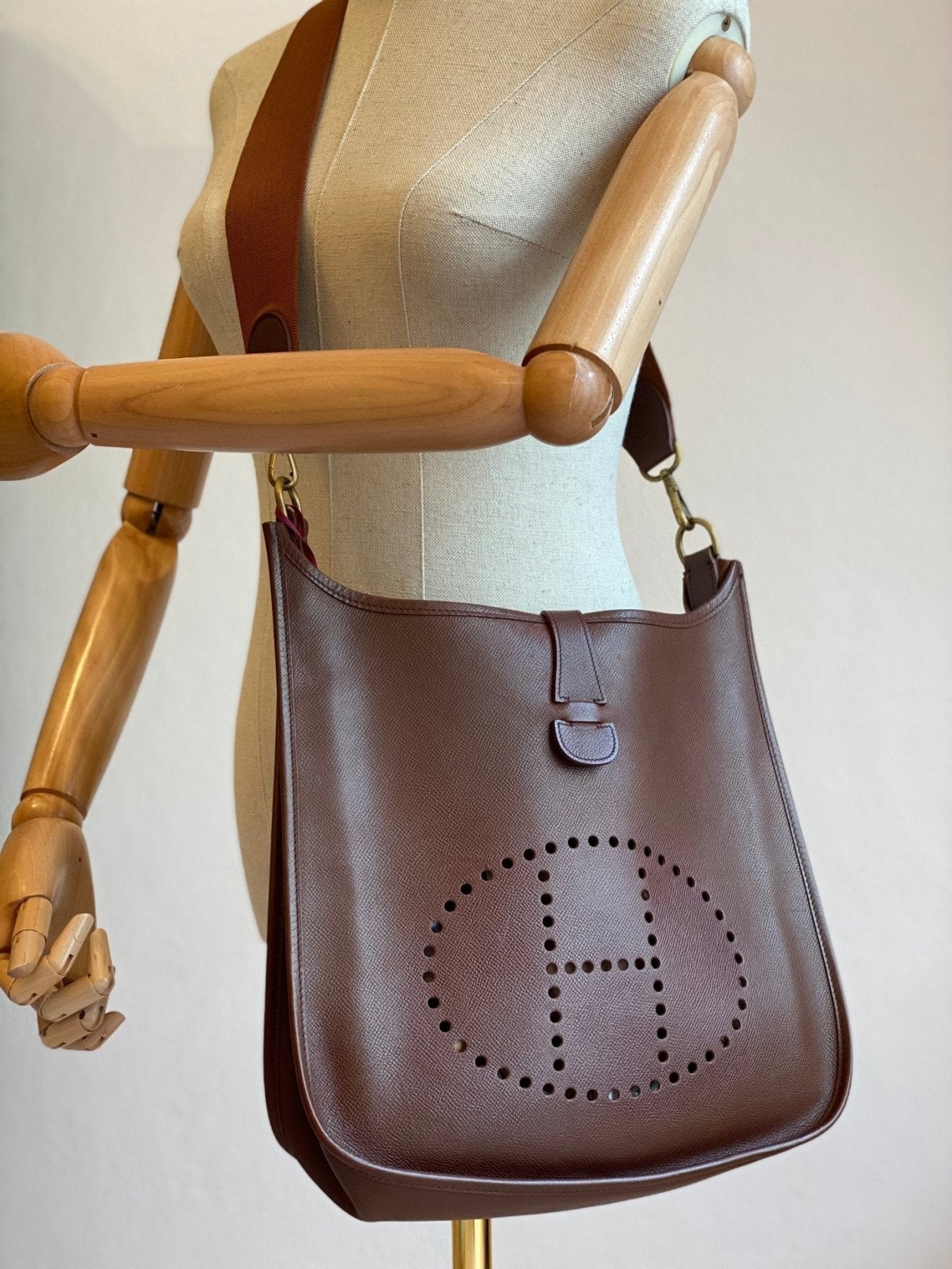 HERMES Evelyne 33 Tasche aus cognacfarbenem Epsomleder mit perforiertem H-Logo auf Schneiderpuppe praesentiert