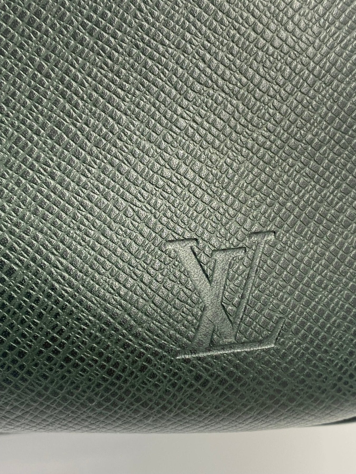 Louis Vuitton Kendall Taiga Epicea Leder Nahaufnahme mit gepraegtem LV Logo auf gruener strukturierter Oberflaeche
