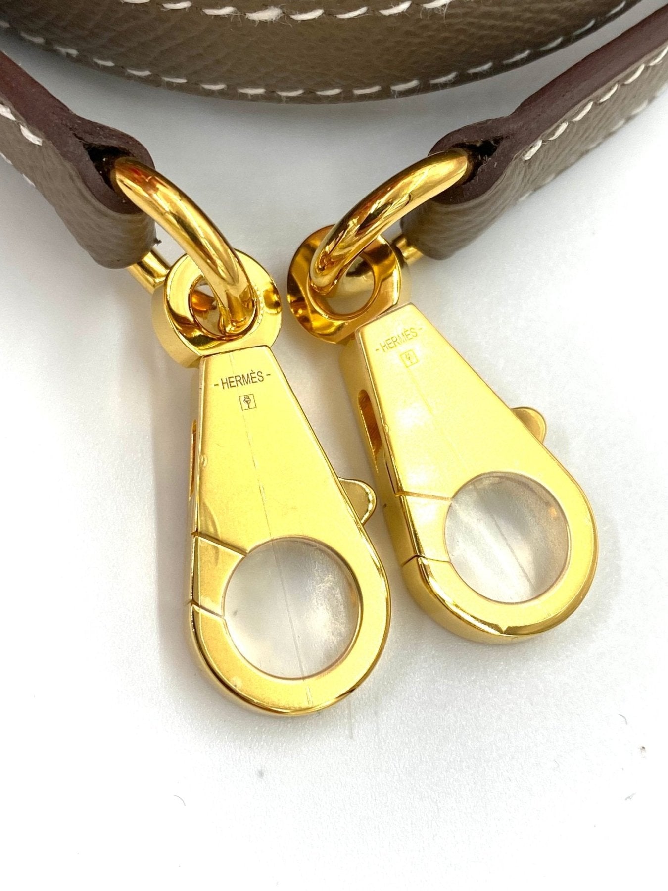Goldene Verschlusskarabiner der HERMÈS Kelly 25 Tasche in Etoupe mit braunen Lederriemen, Nahaufnahme der Details