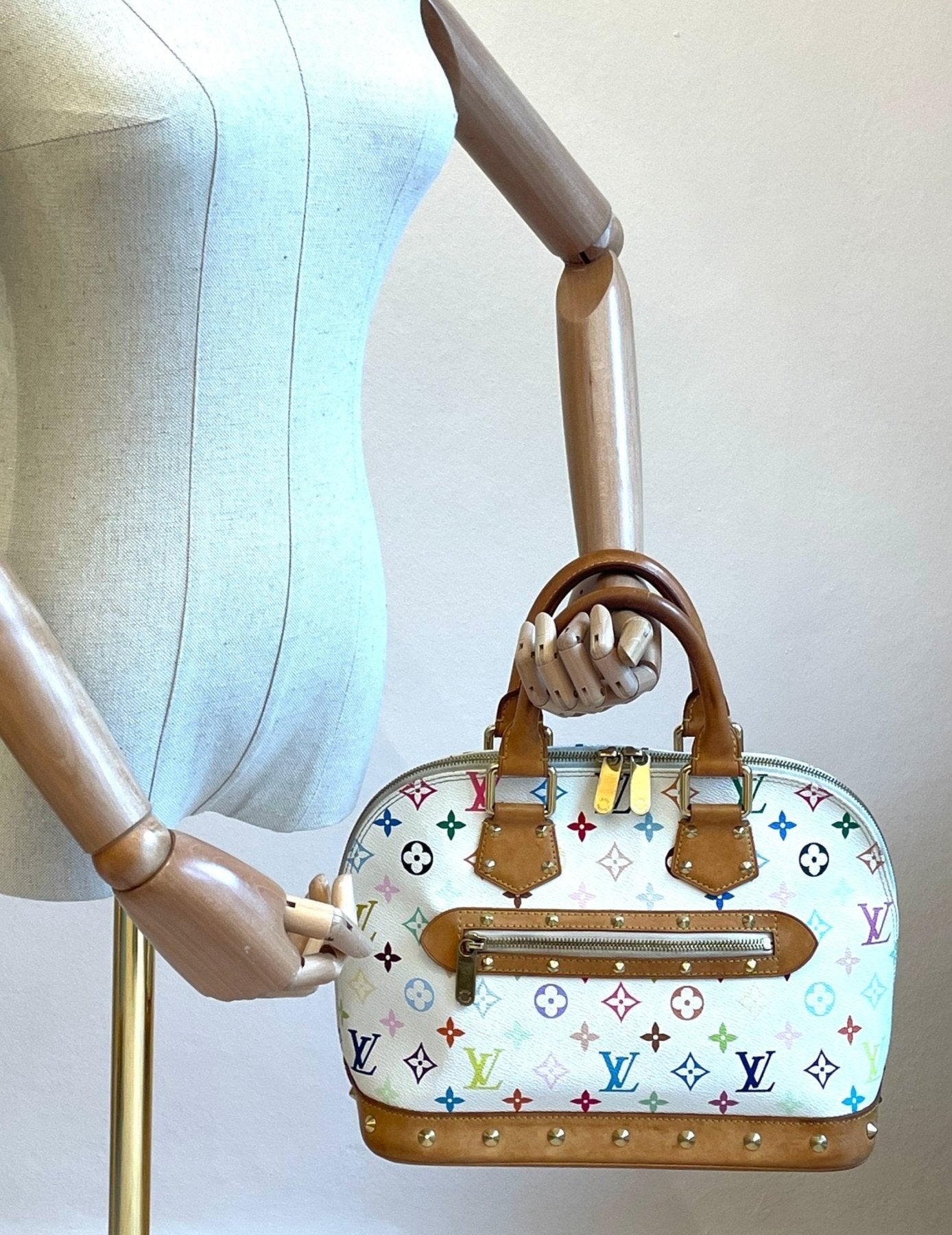 Louis Vuitton Alma Multicolor Handtasche mit buntem Monogram-Muster und braunen Ledergriffen auf Schaufensterpuppe