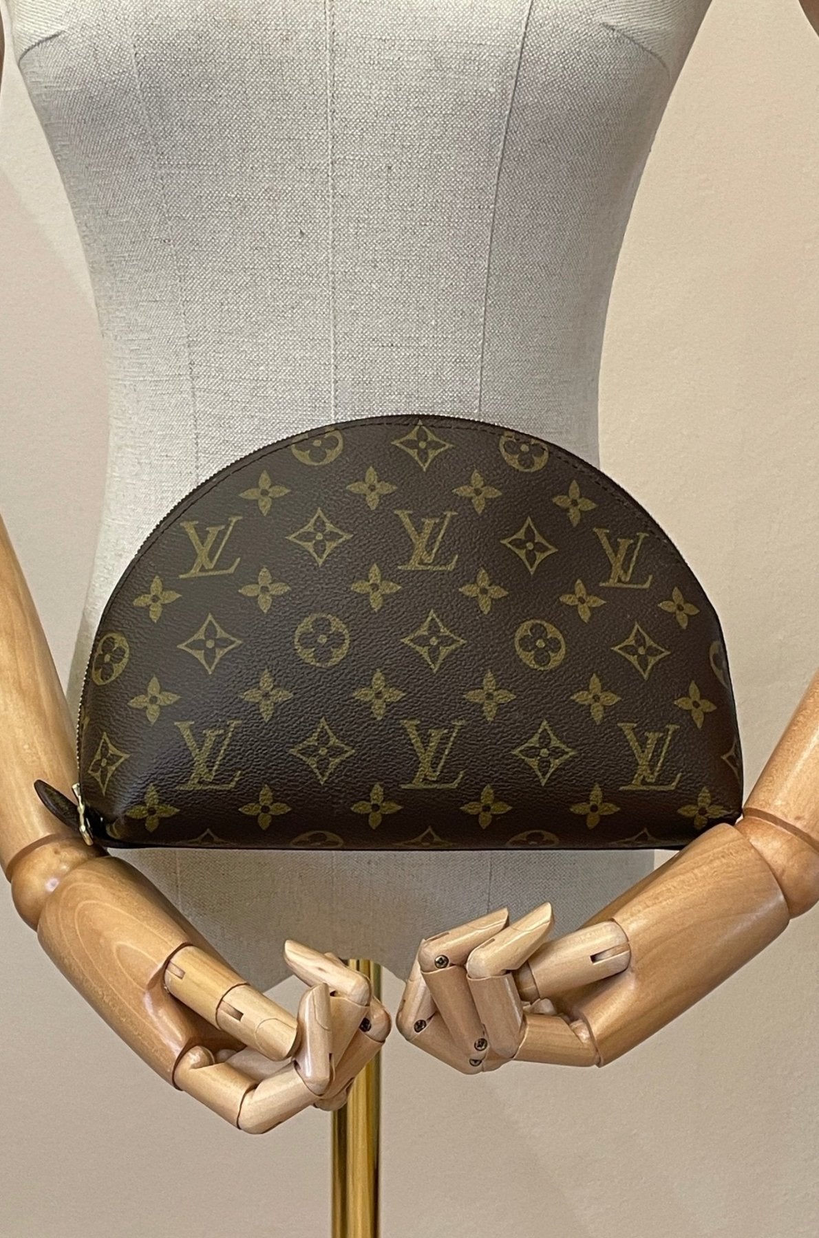 Louis Vuitton Trousse Demi Ronde Monogram Canvas Kosmetiktasche auf Schneiderpuppe mit holzernen Handen prasentiert