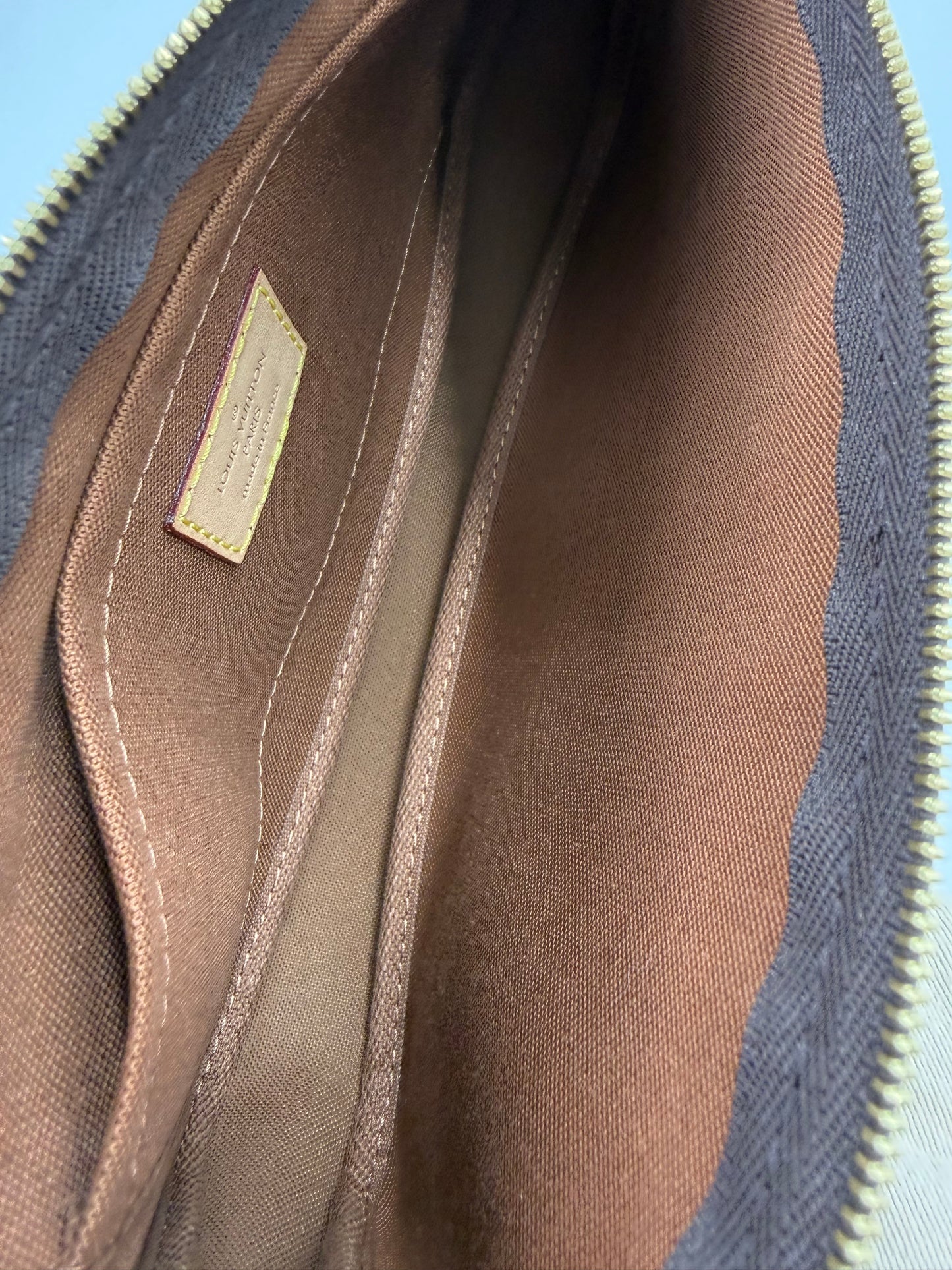 Innenansicht der LOUIS VUITTON Multi Pochette Monogram Canvas mit braunem Innenfutter und Reißverschlussfach, hochwertig verarbeitet.