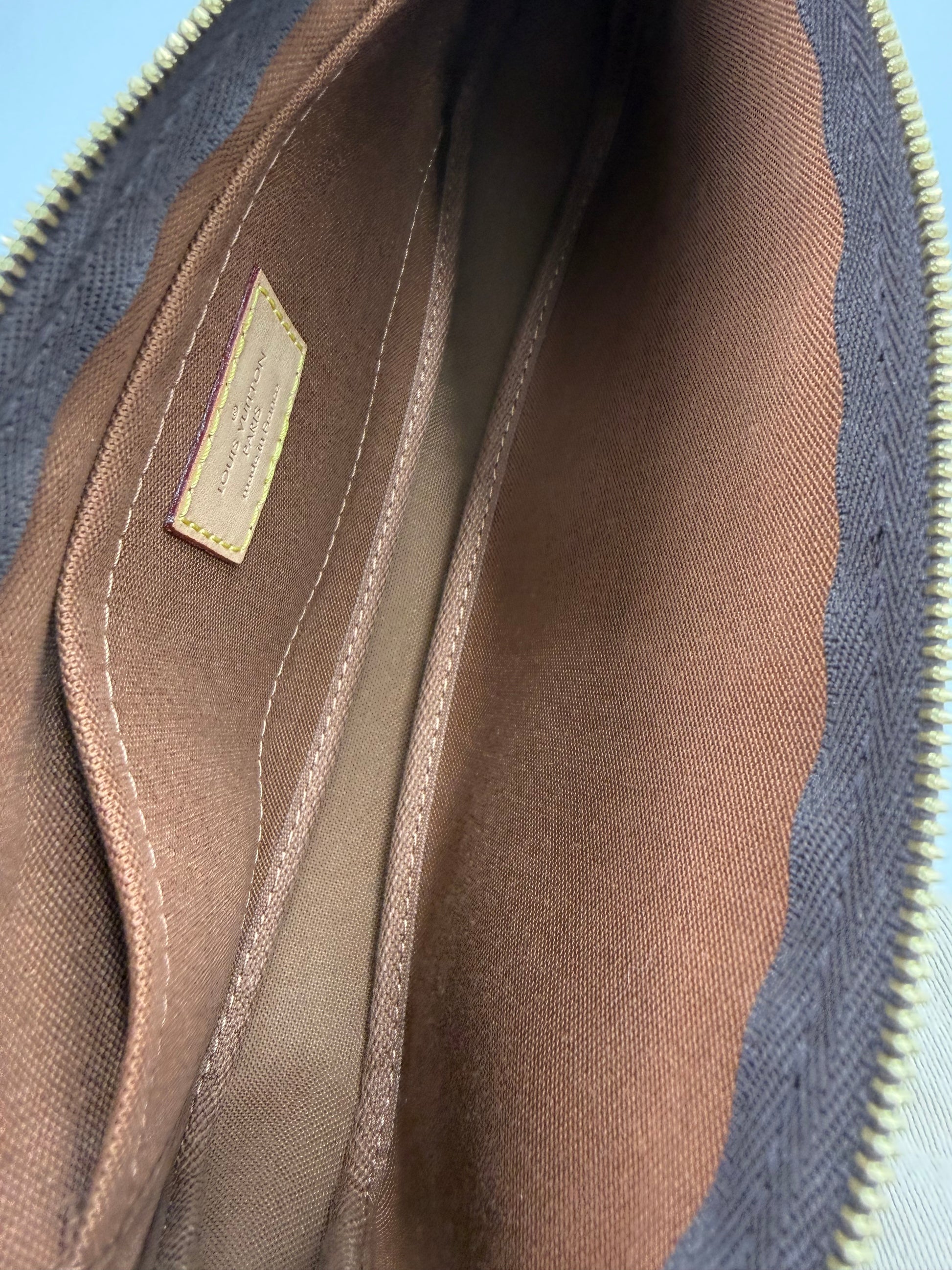 Innenansicht der LOUIS VUITTON Multi Pochette Monogram Canvas mit braunem Innenfutter und Reißverschlussfach, hochwertig verarbeitet.