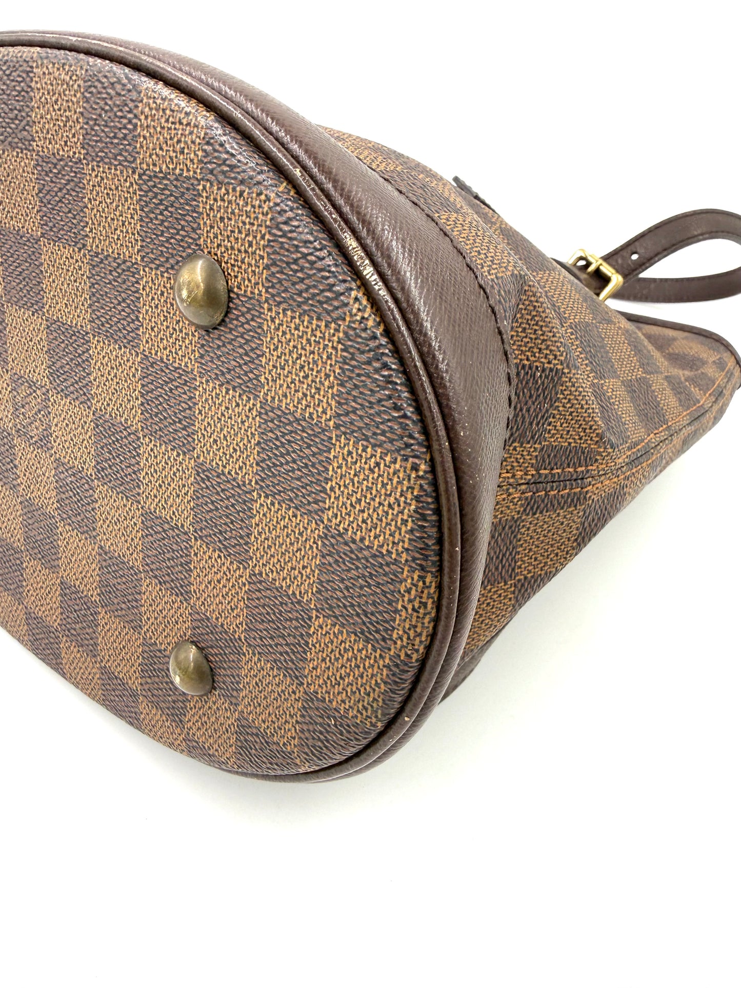 LOUIS VUITTON Bucket Bag PM Damier Ebene Detailaufnahme des Taschenbodens mit charakteristischen Messingfüßen und Schachbrettmuster
