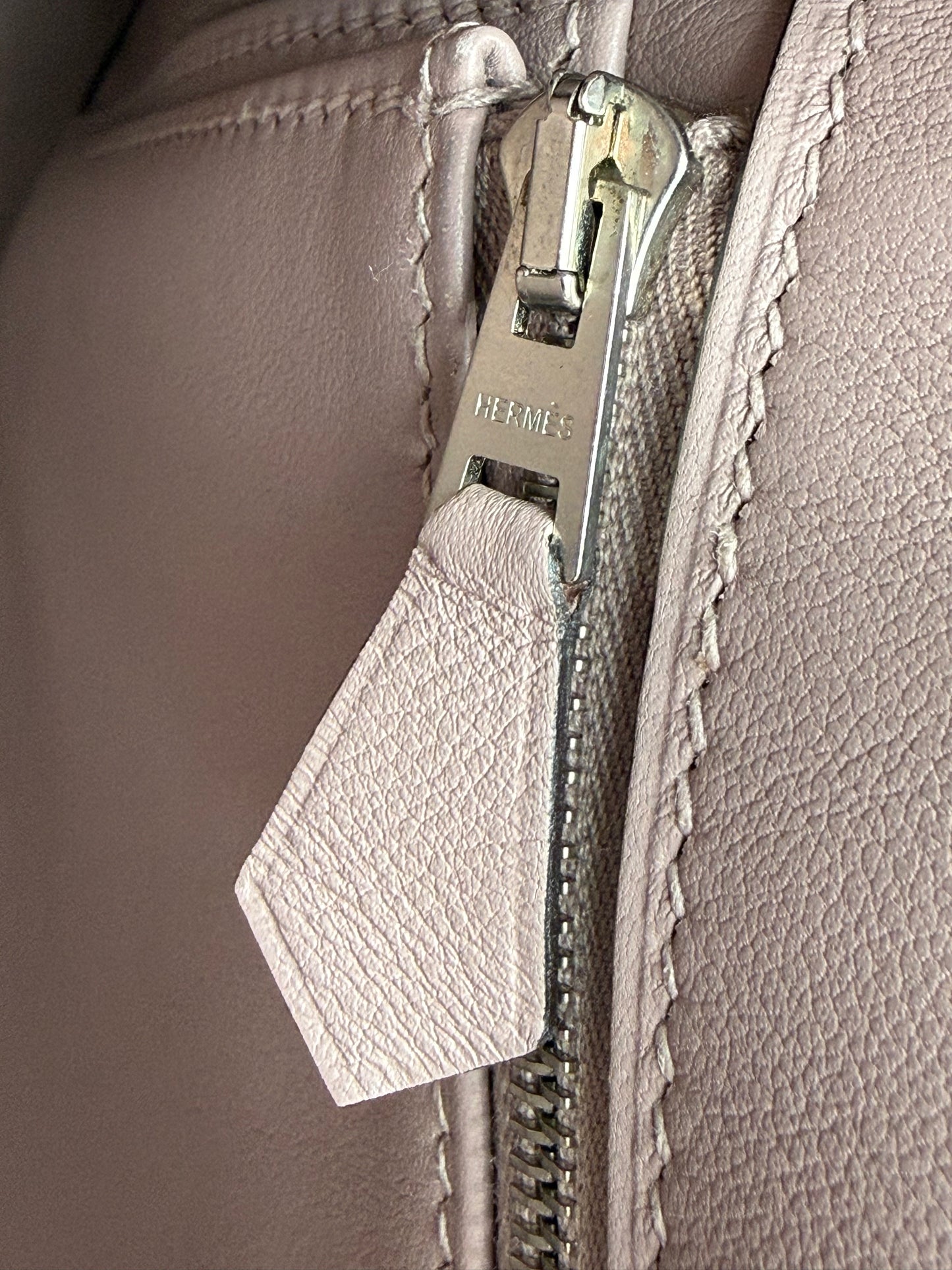 Naheaufnahme des Reißverschlusses einer HERMÈS Berline 29 taupe PHW eleganten Lederhandtasche.