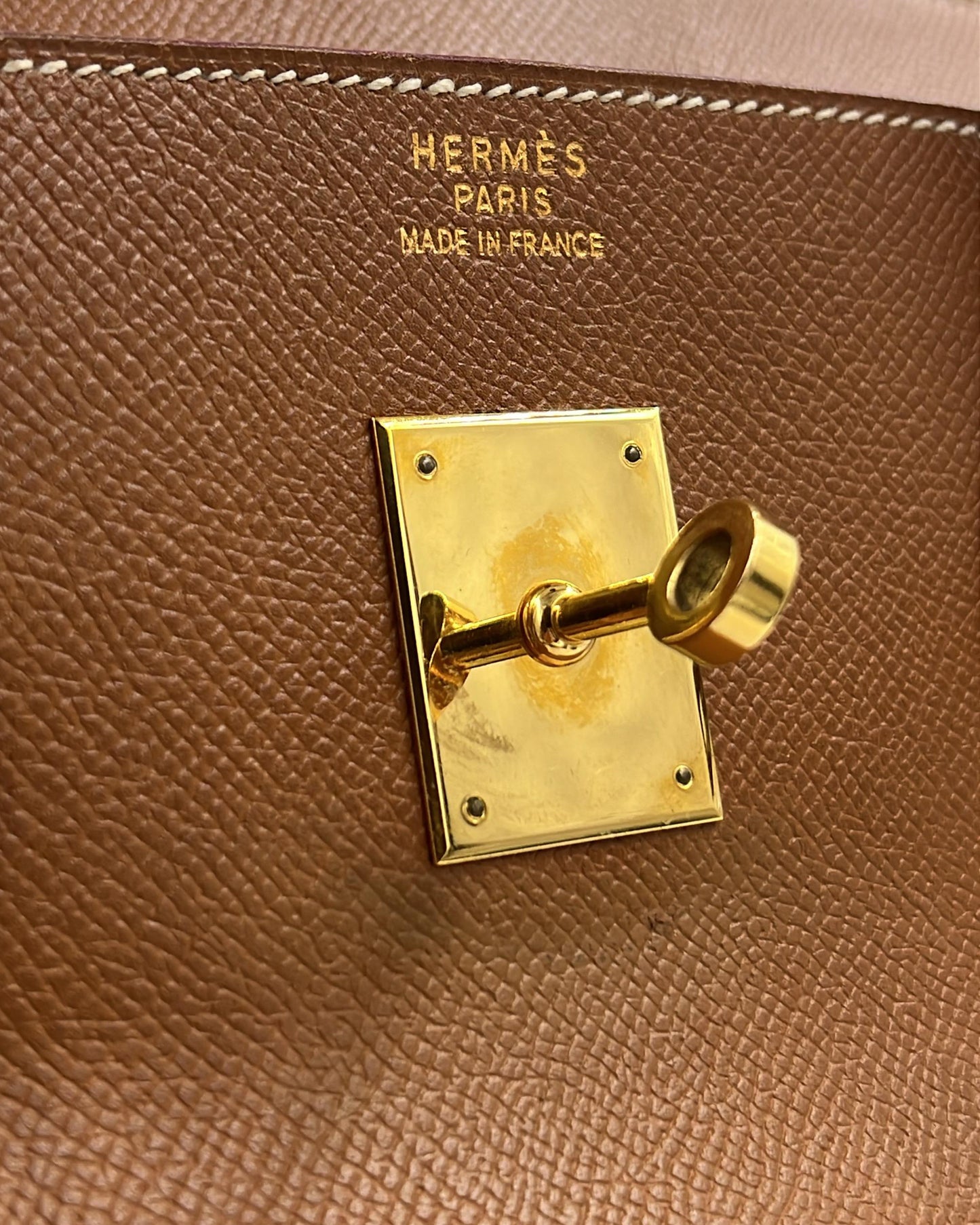 HERMÈS Birkin 40 Courchevel gold GHW Detailaufnahme mit goldfarbenem Drehverschluss und geprägtem Hermès Paris Logo