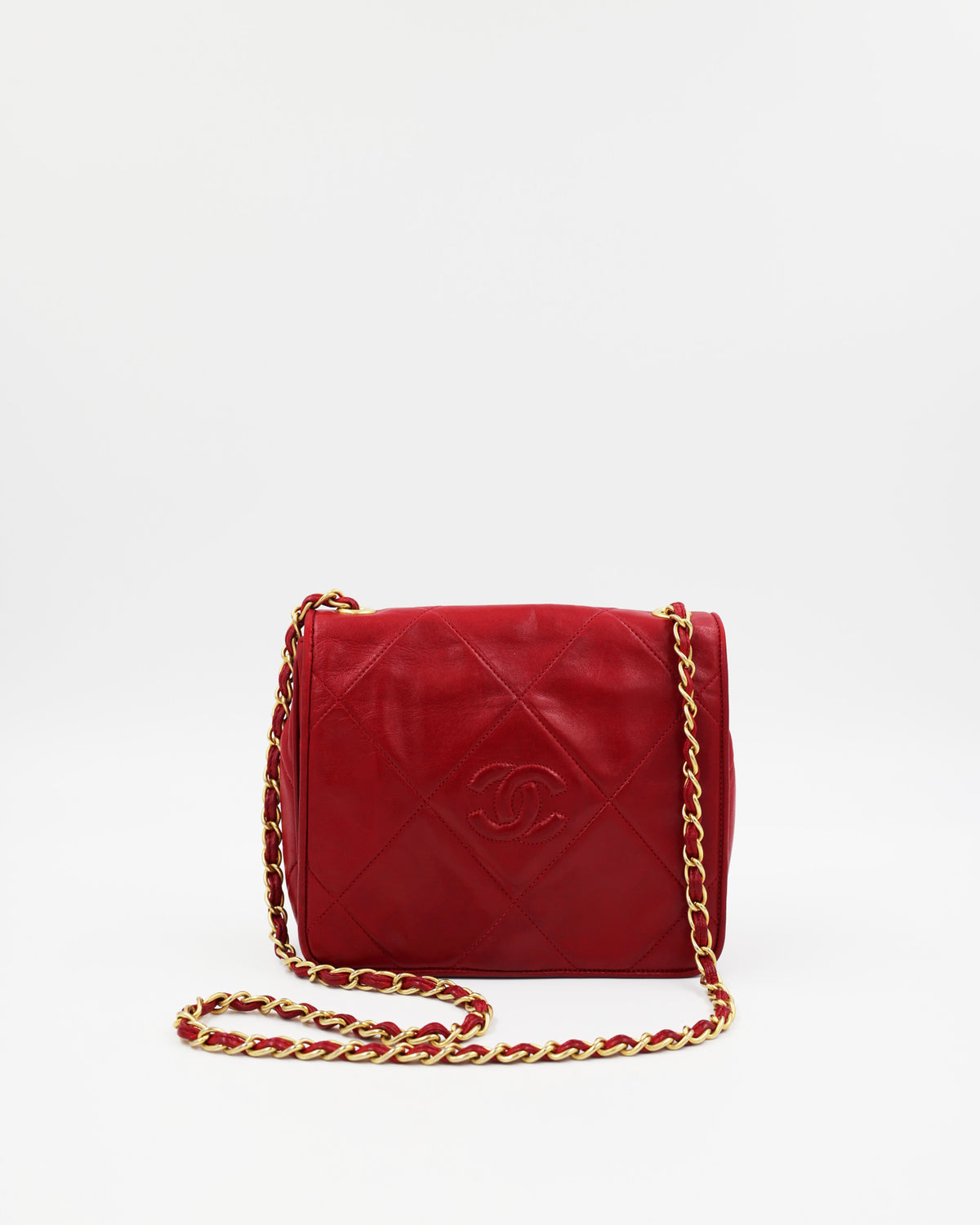 Rote CHANEL Schultertasche mit Rautensteppung und goldfarbener Kette auf weißem Hintergrund