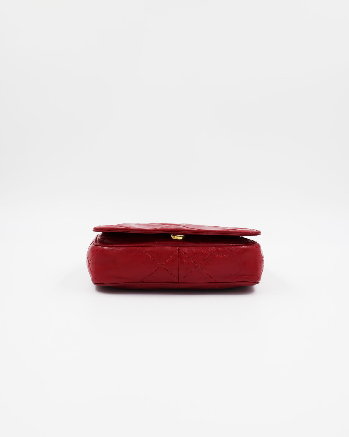Rote gesteppte Clutch mit goldfarbenem Verschluss auf weißem Hintergrund