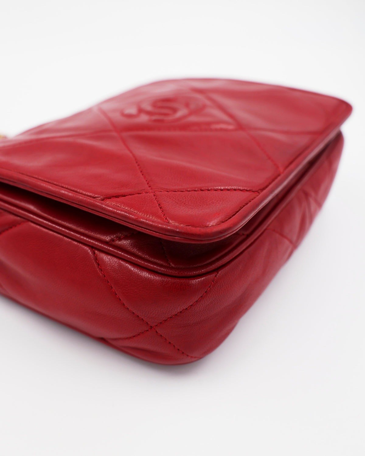Rote gesteppte Handtasche mit abgerundeten Kanten auf weißem Hintergrund