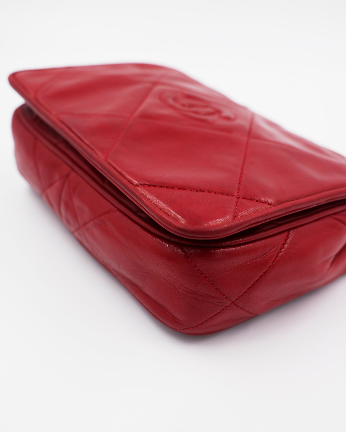 Rote gesteppte Clutch aus Leder mit Umschlag und Reißverschluss auf weißem Hintergrund