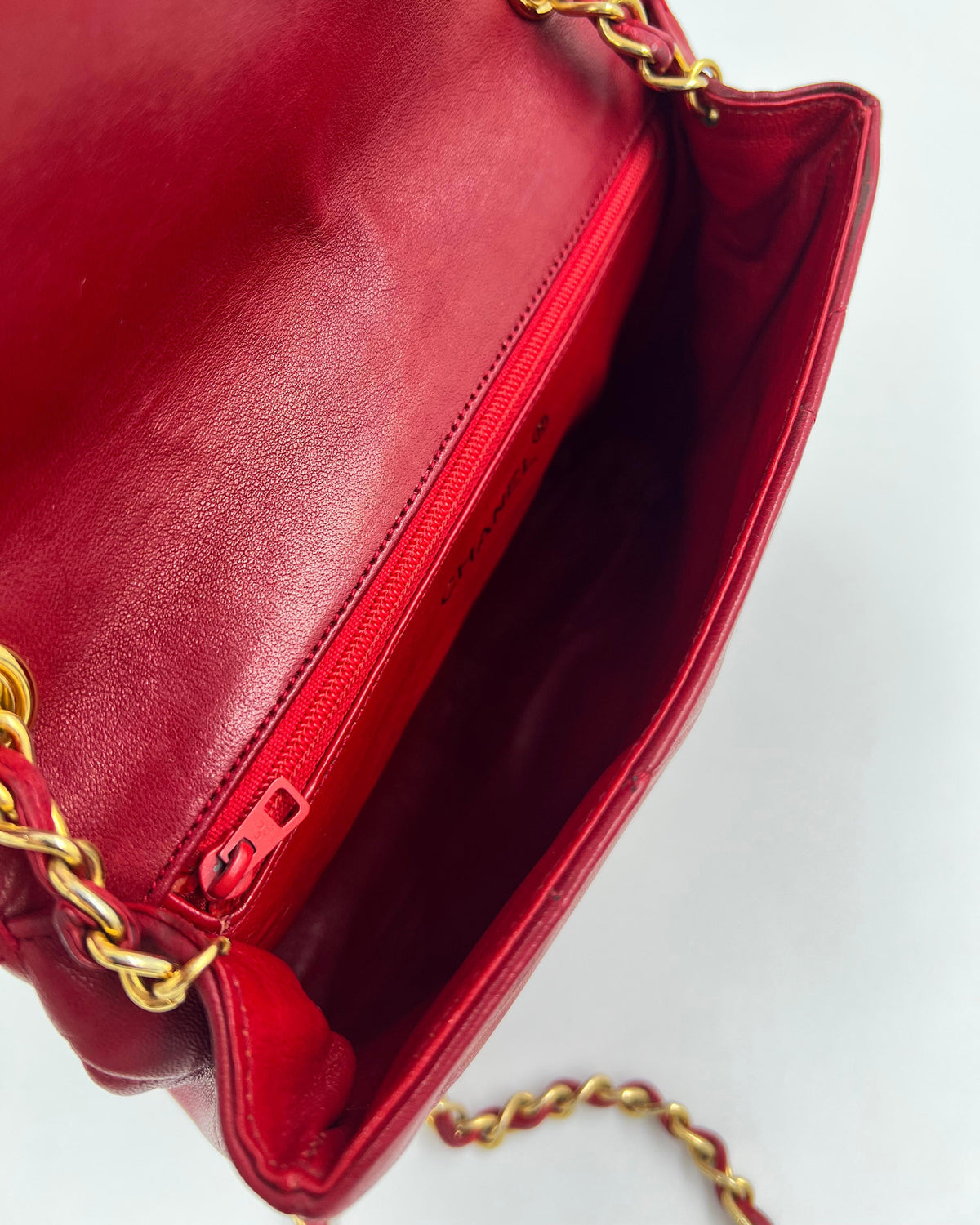 Offene rote Ledertasche mit goldener Kette und Reißverschlussfach