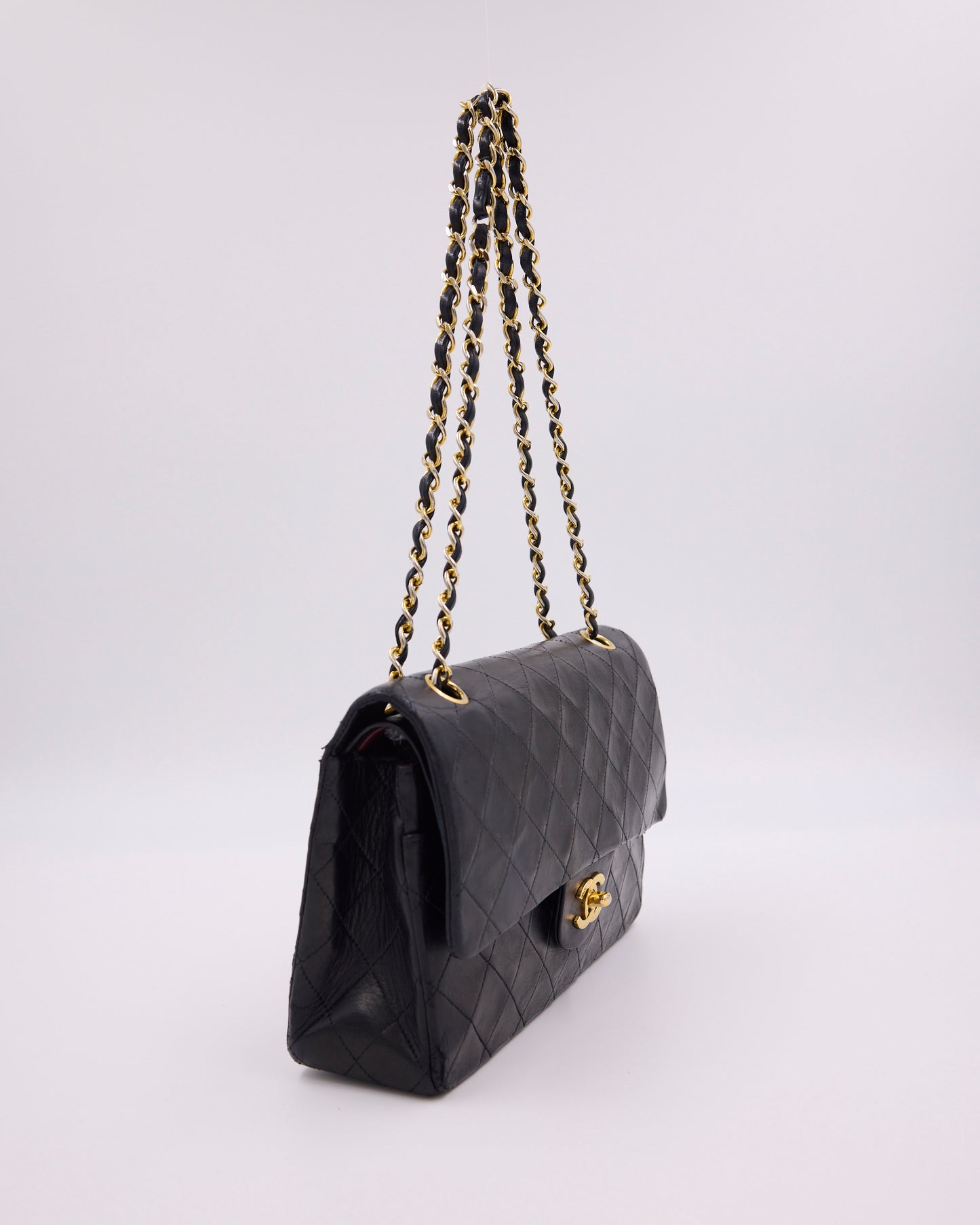 Schwarze gesteppte Designerhandtasche mit Kettenriemen und goldfarbenem Verschluss