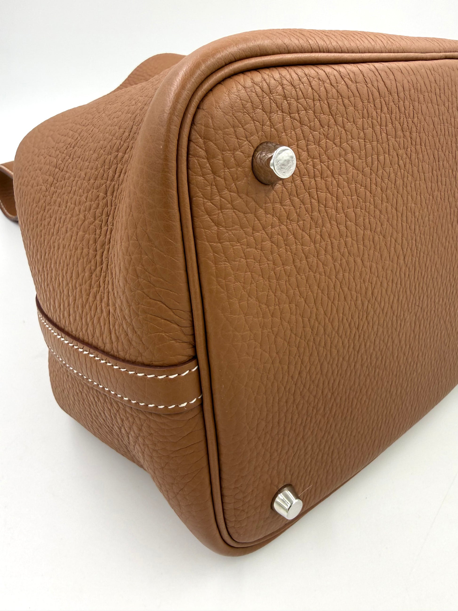 Hochwertige Detailaufnahme der HERMÈS Picotin 26 Lock Clemence gold PHW Designer Handtasche in braunem Leder.