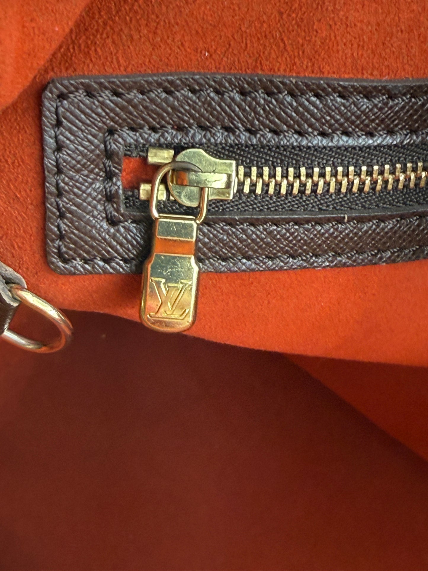 LOUIS VUITTON Bucket Bag PM Damier Ebene Nahaufnahme Reißverschluss mit goldfarbenem LV-Logo und rotem Innenfutter