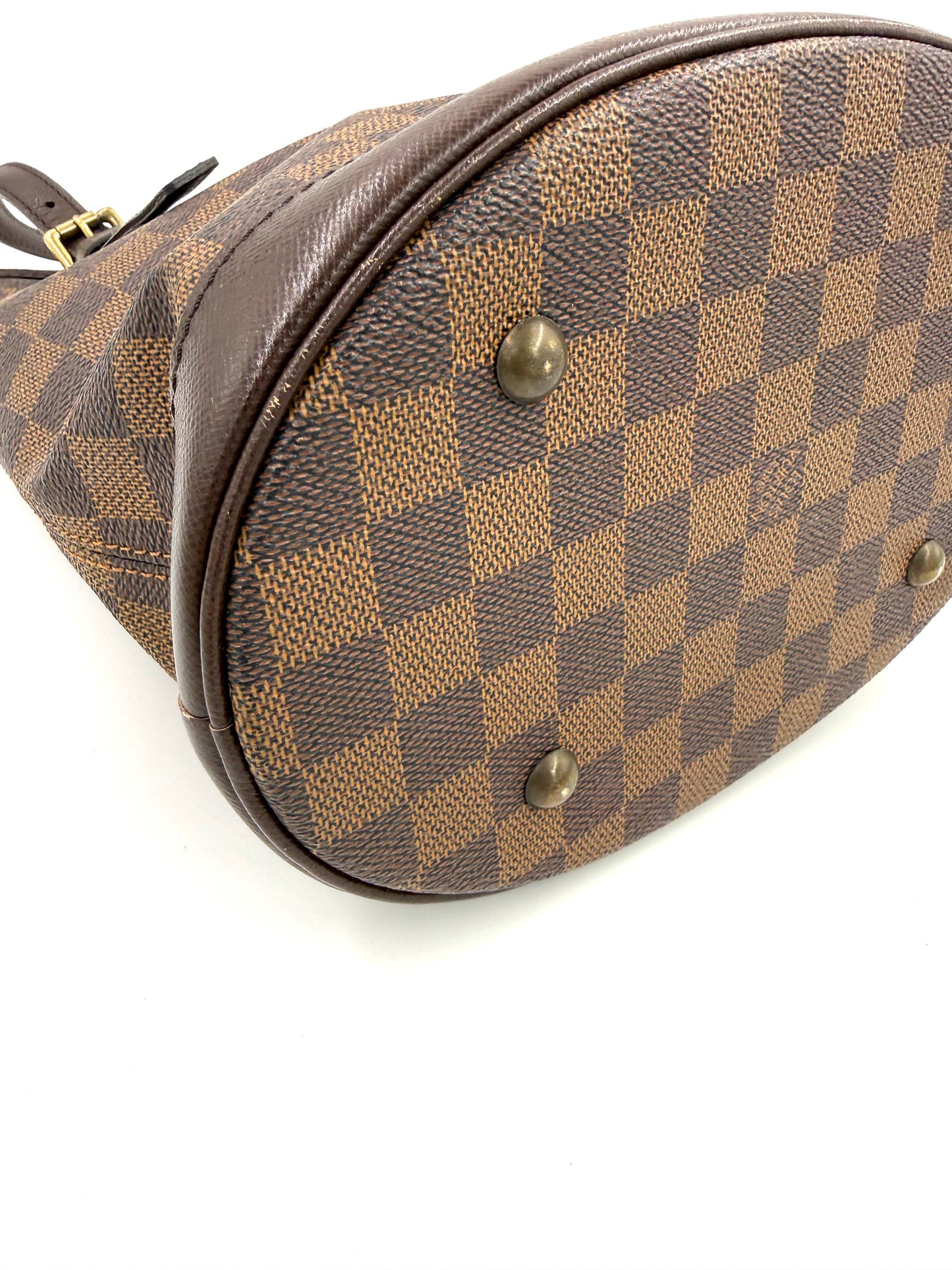 LOUIS VUITTON Bucket Bag PM Damier Ebene Boden mit typischen Messingfüßen und braunem Lederbesatz nahaufnahme
