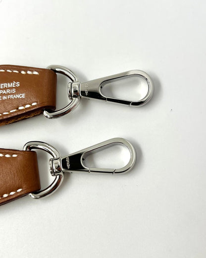 HERMÈS Evelyne 16 Clemence gold PHW Detailansicht mit braunem Leder und silberfarbenen Karabinerhaken