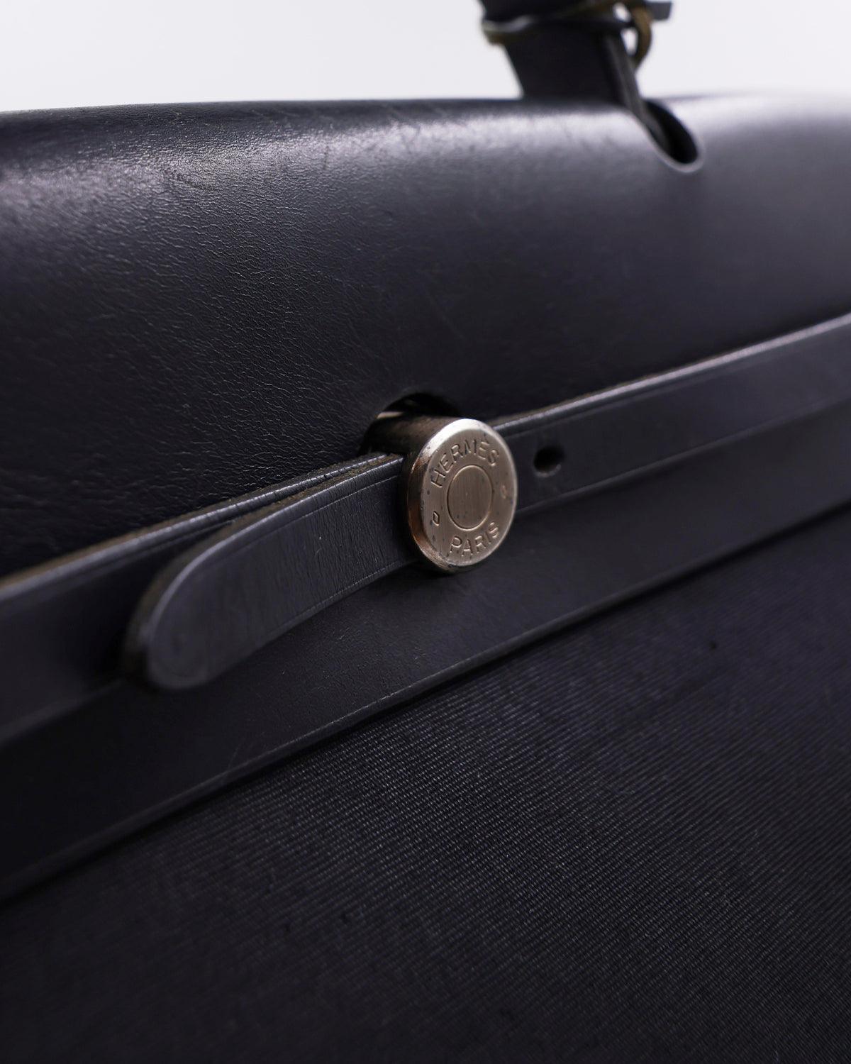 HERMÈS Herbag 39 Messenger schwarz PHW Detailaufnahme mit schwarzem Riemen und silberfarbenem Verschluss
