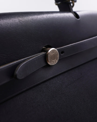 HERMÈS Herbag 39 Messenger schwarz PHW Detailaufnahme mit schwarzem Riemen und silberfarbenem Verschluss