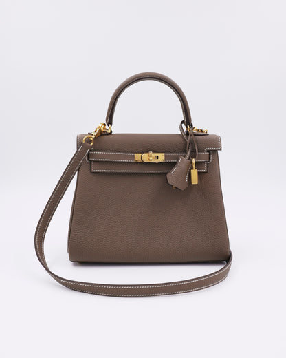 HERMÈS Kelly 25 Togo Etoupe GHW, taupefarbene Designerhandtasche aus Leder mit goldfarbenen Beschlägen