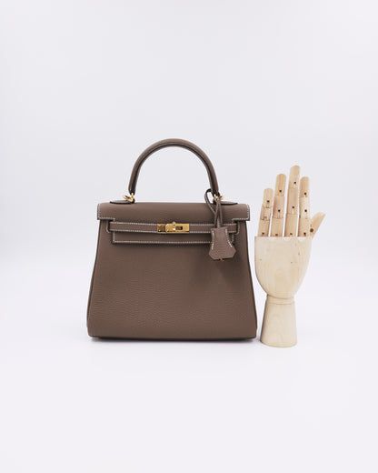 HERMÈS Kelly 25 Togo Etoupe GHW in Taupe mit goldfarbenen Beschlägen