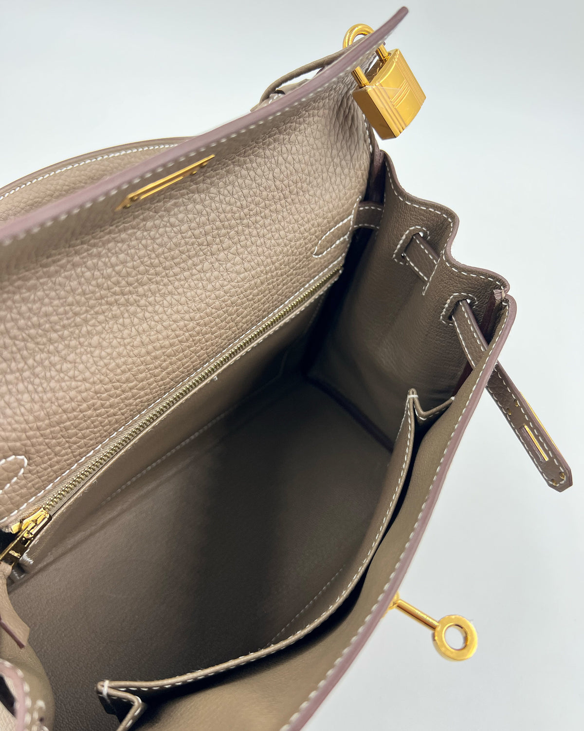 HERMÈS Kelly 25 Togo Etoupe GHW Innenansicht einer luxuriösen Designerhandtasche aus Leder mit goldfarbenen Details