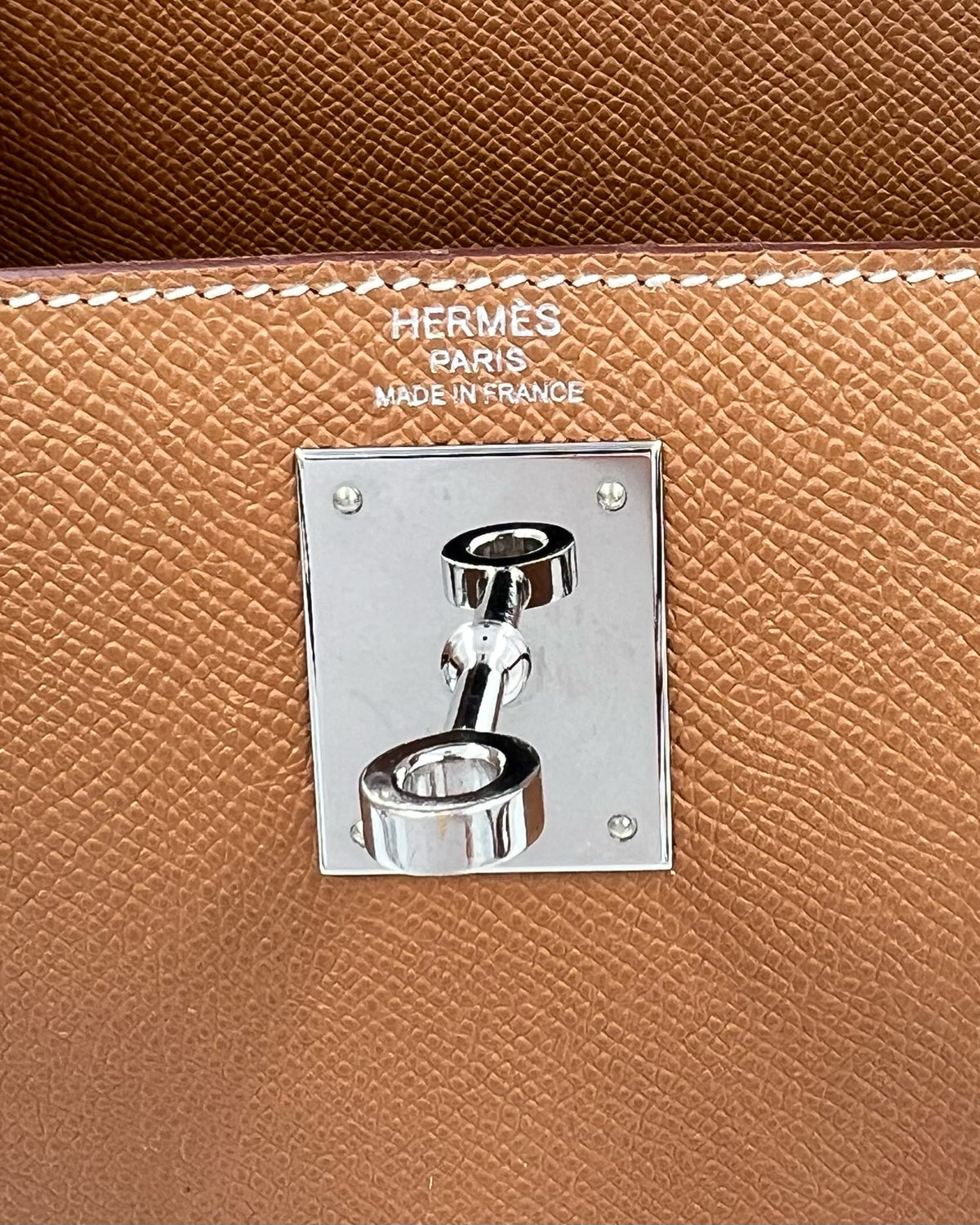 Detailaufnahme der HERMÈS Kelly 28 Epsom Sellier Gold PHW inklusive Twilly mit silberfarbenem Verschluss