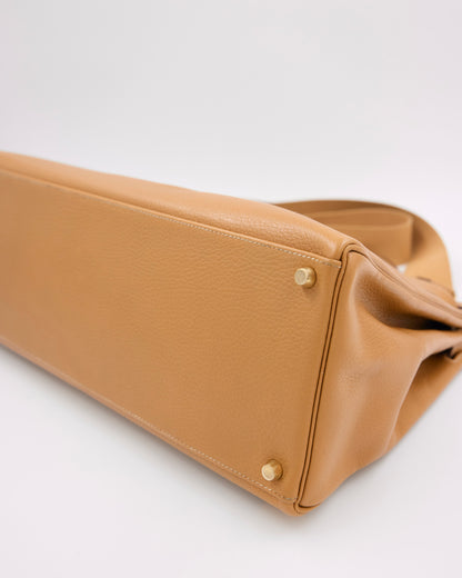 HERMÈS Kelly 40 beige GWH Unterseite einer Designerhandtasche mit goldfarbenen Standfüßen