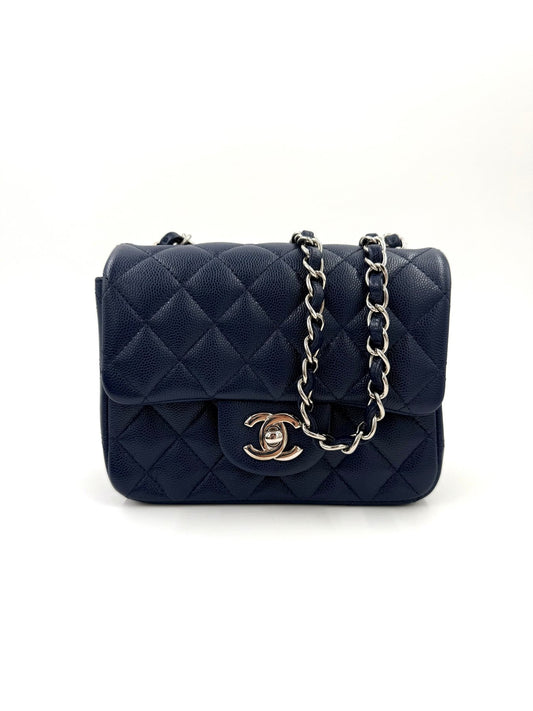 CHANEL Mini Square Flap Bag Caviar blau mit gesteppter Oberfläche und silberner Kettenriemen in elegantem Design.