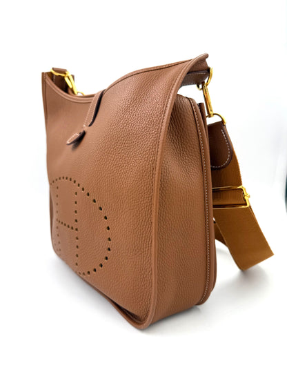 HERMÈS Evelyne 33 Clemenceleder Gold GHW Seitenansicht in warmem Braun mit perforiertem H-Logo und verstellbarem Schulterriemen