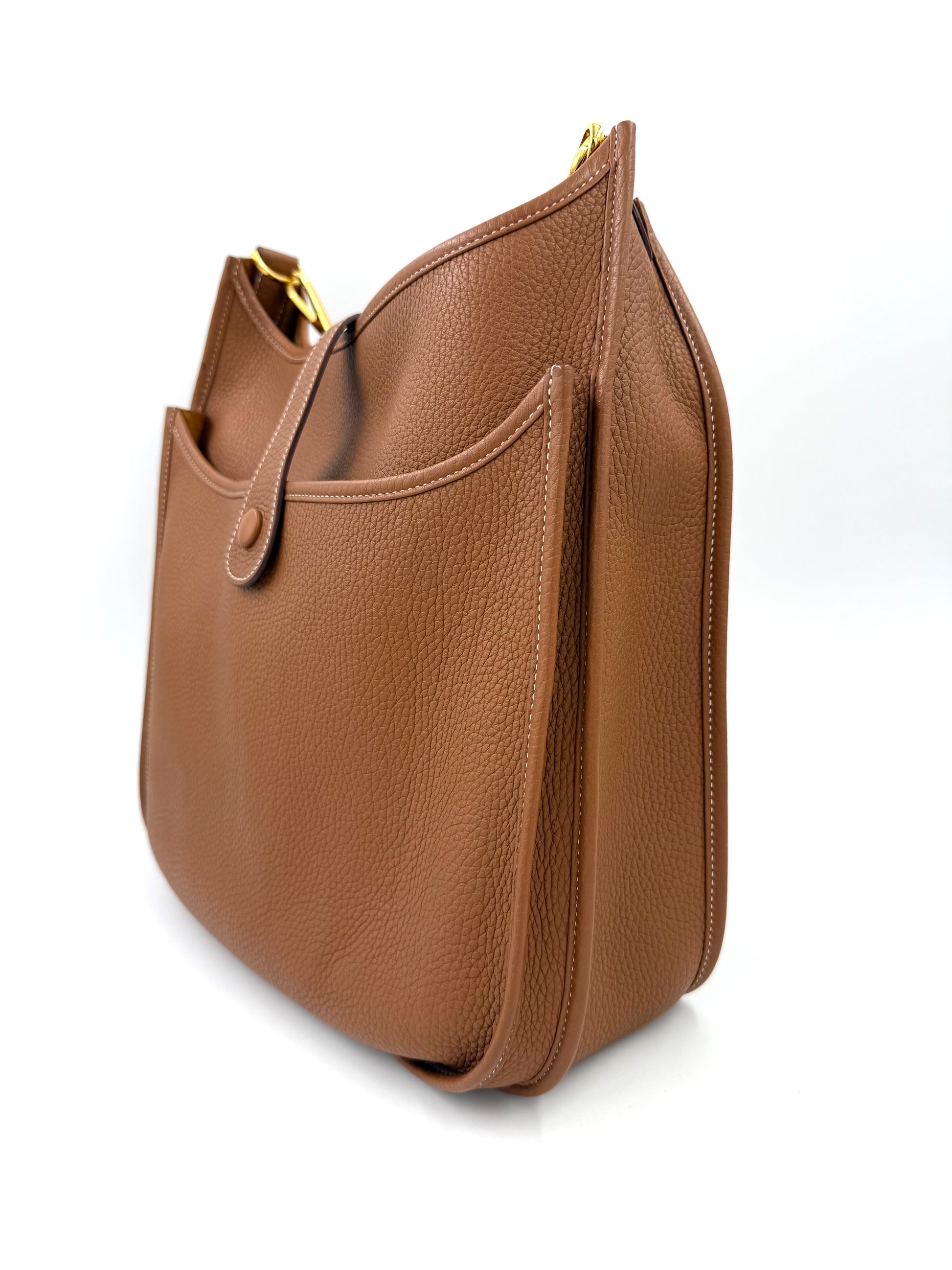 HERMÈS Evelyne 33 Clemenceleder Gold GHW seitliche Ansicht in warmem Braun mit außenliegender Tasche und feiner Lederstruktur