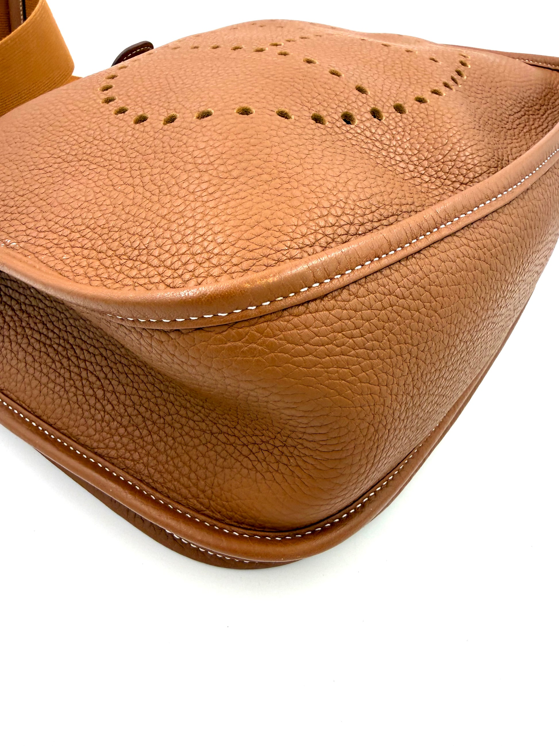 HERMÈS Evelyne 33 Clemenceleder Gold GHW Nahaufnahme der genarbten Kante mit feiner weißer Naht und Lochmuster in Cognacfarben