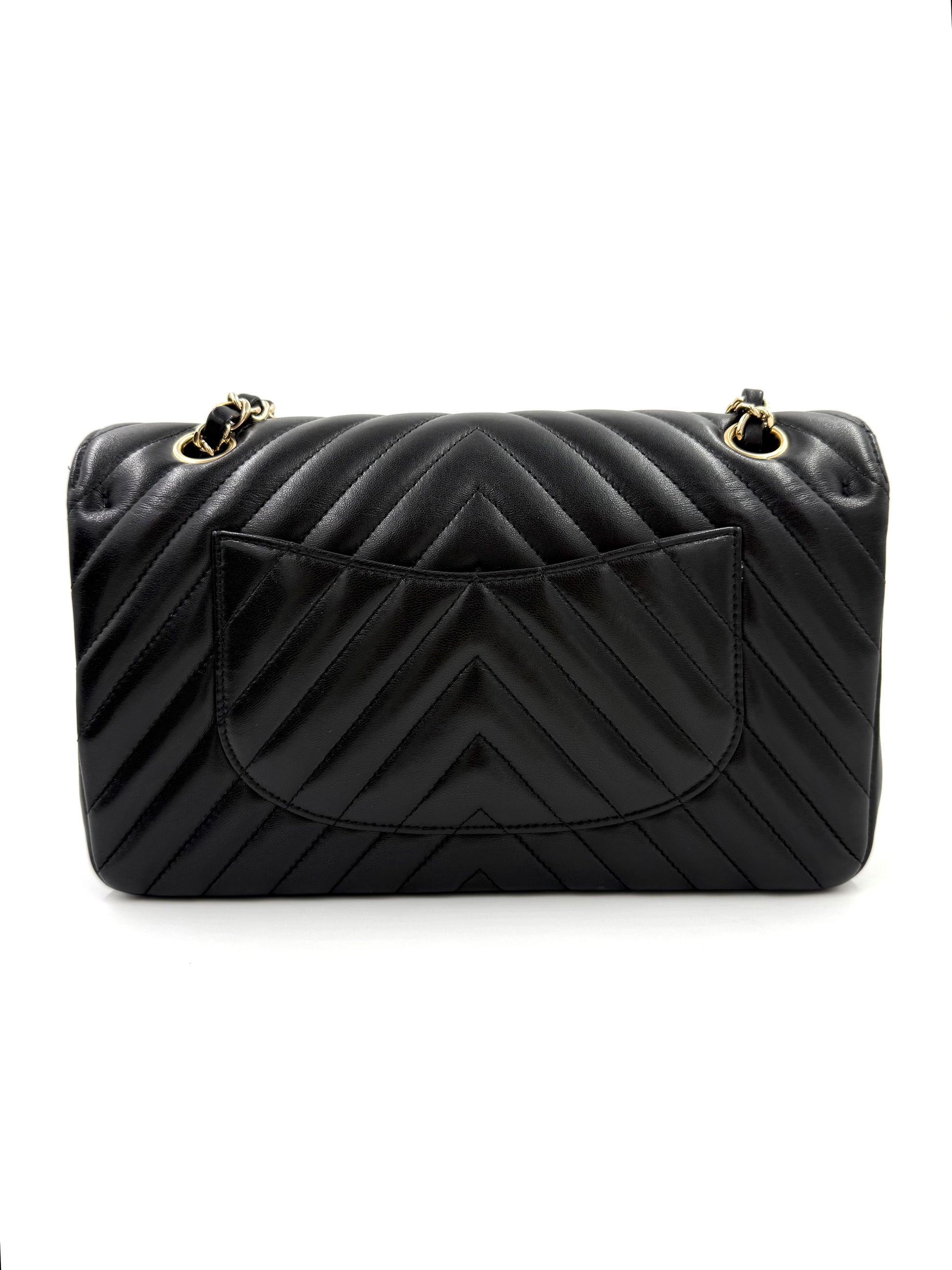 CHANEL Timeless Double Flap medium Chevron schwarz in schwarzem Leder mit goldfarbenen Details und charakteristischem Chevron-Muster.