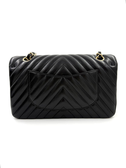 CHANEL Timeless Double Flap medium Chevron schwarz in schwarzem Leder mit goldfarbenen Details und charakteristischem Chevron-Muster.
