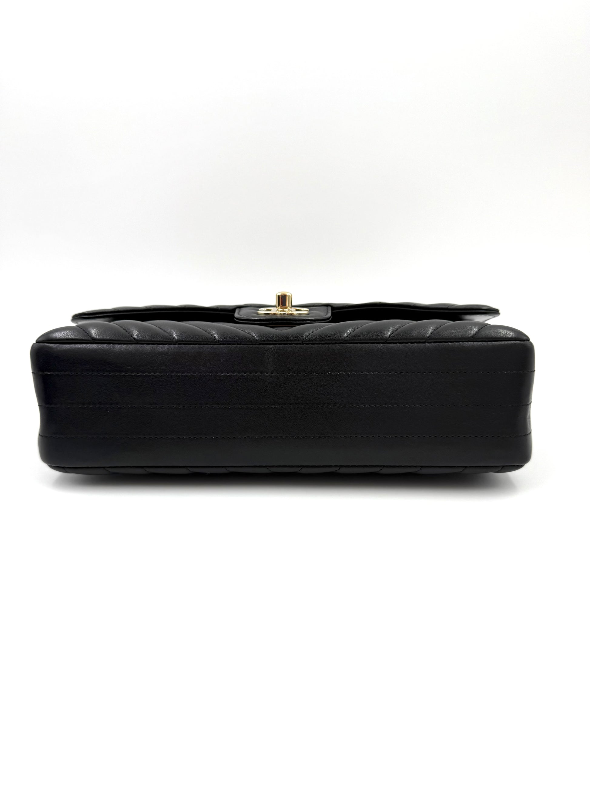 CHANEL Timeless Double Flap medium Chevron schwarz mit schwarzem glänzendem Leder und goldfarbener Schließe, Seitenansicht.
