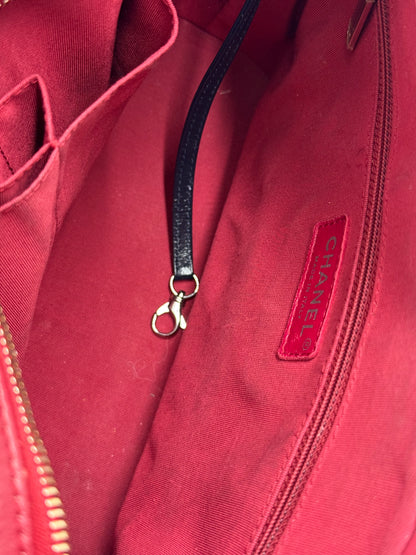 CHANEL Gabrielle medium dunkelblau Innenansicht mit rotem Stofffutter, Reißverschlusstasche und Lederriemen mit Karabinerhaken