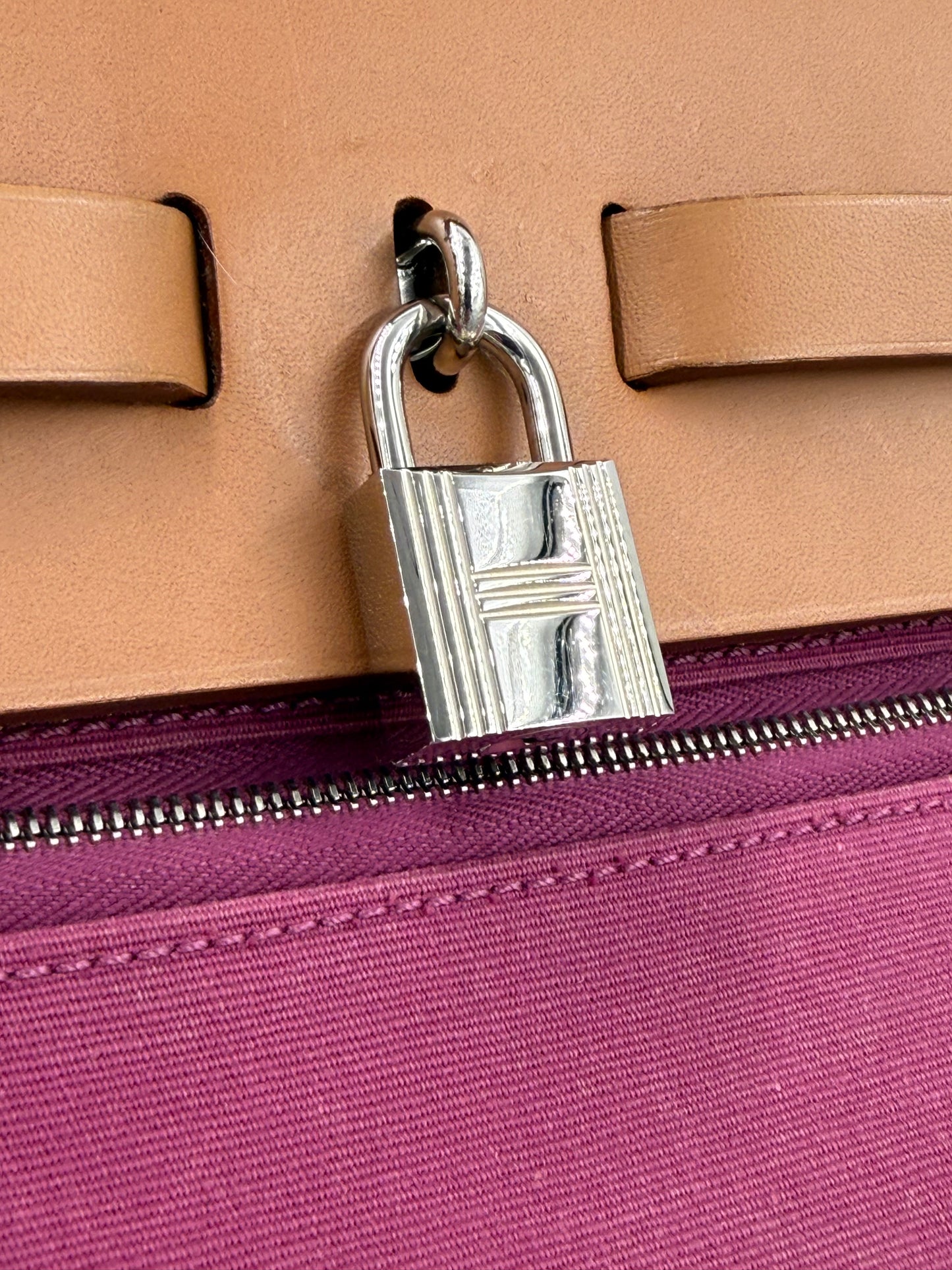 Nahaufnahme des silbernen Schlosses der HERMÈS Herbag 39 Zip pink auf braunem Leder mit pinkem Reißverschluss