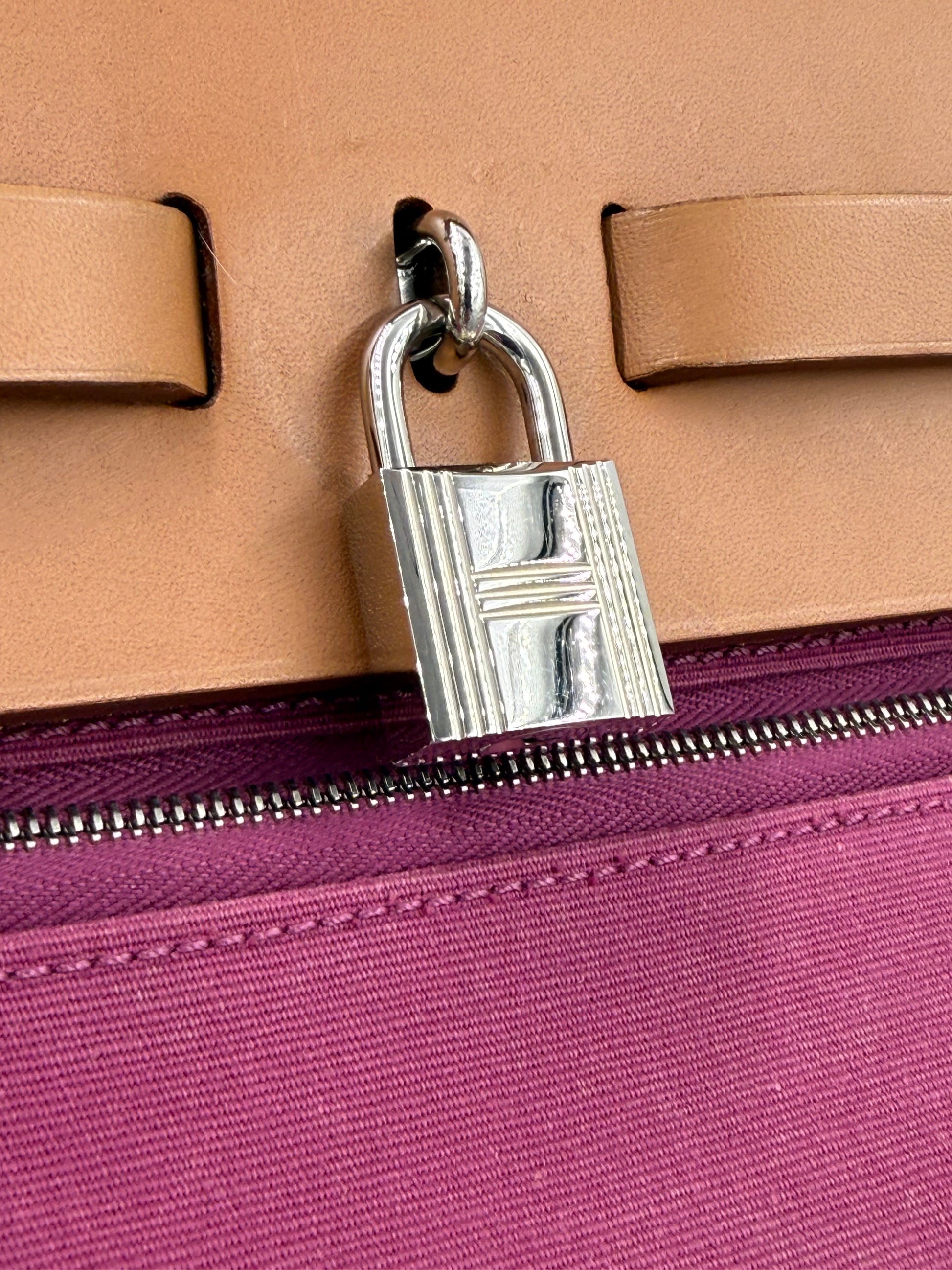 Nahaufnahme des silbernen Schlosses der HERMÈS Herbag 39 Zip pink auf braunem Leder mit pinkem Reißverschluss
