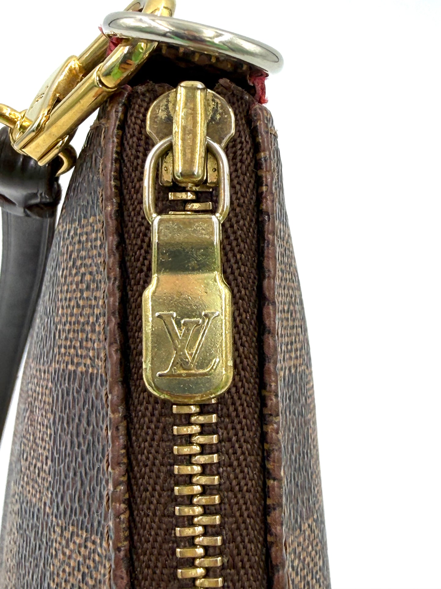 Nahaufnahme des goldfarbenen LV-Reißverschlusses der LOUIS VUITTON Pochette Accessoires Damier Ebene Handtasche.
