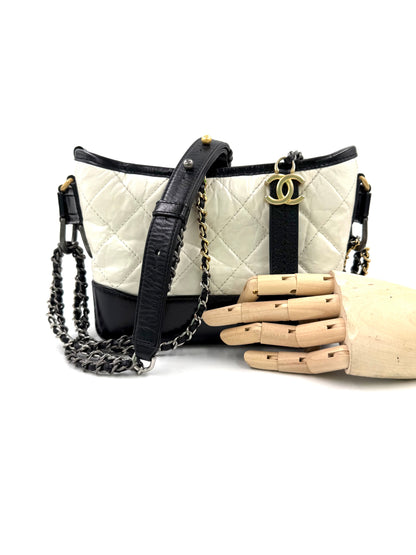 Elegante CHANEL Gabrielle small weiß/schwarz Designerhandtasche mit goldfarbenen Details und Kettenriemen, second hand.
