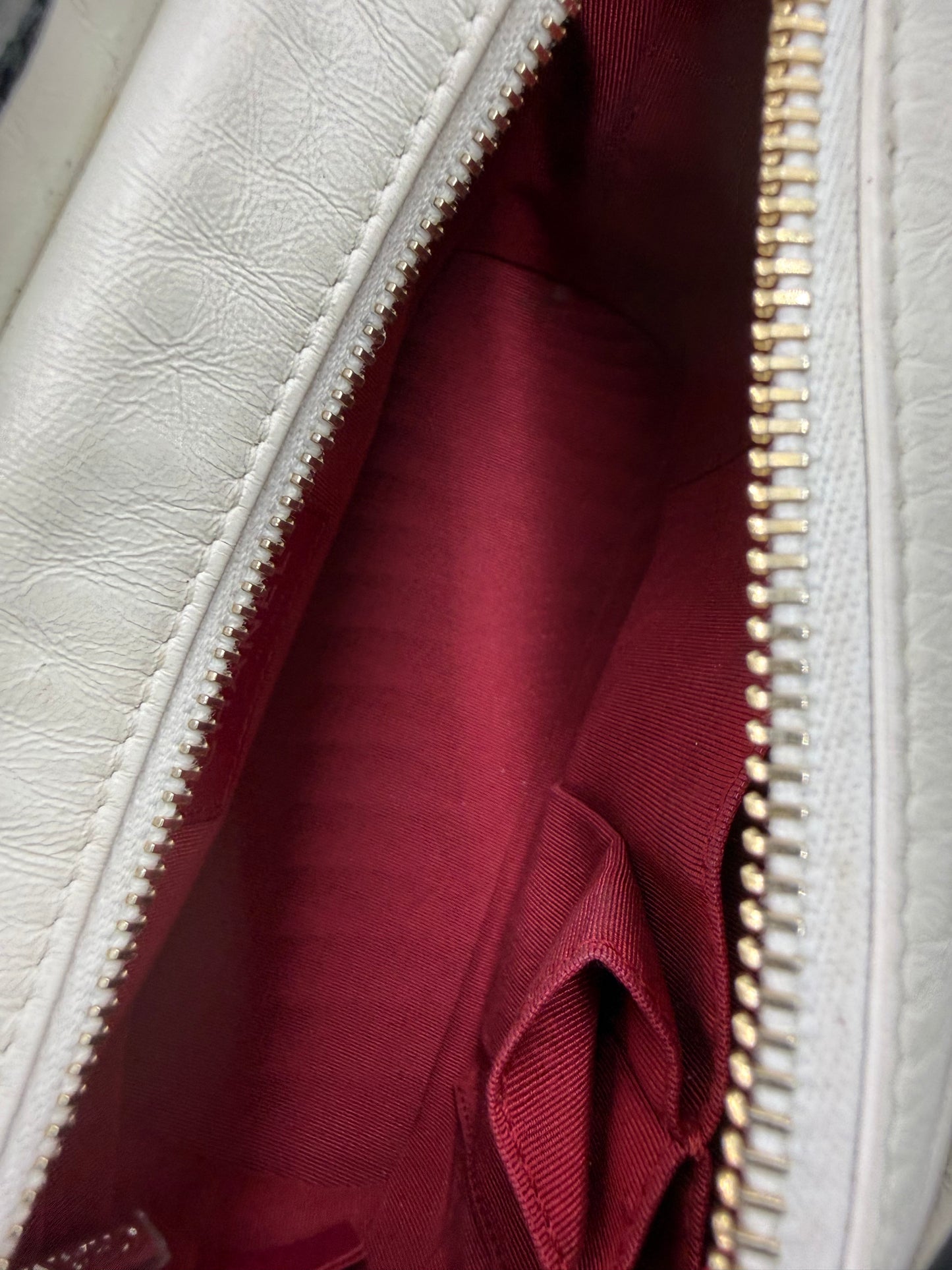 Innenansicht der CHANEL Gabrielle small weiß/schwarz mit rotem Futter und Reißverschluss in hochwertiger Verarbeitung.