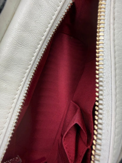 Innenansicht der CHANEL Gabrielle small weiß/schwarz mit rotem Futter und Reißverschluss in hochwertiger Verarbeitung.