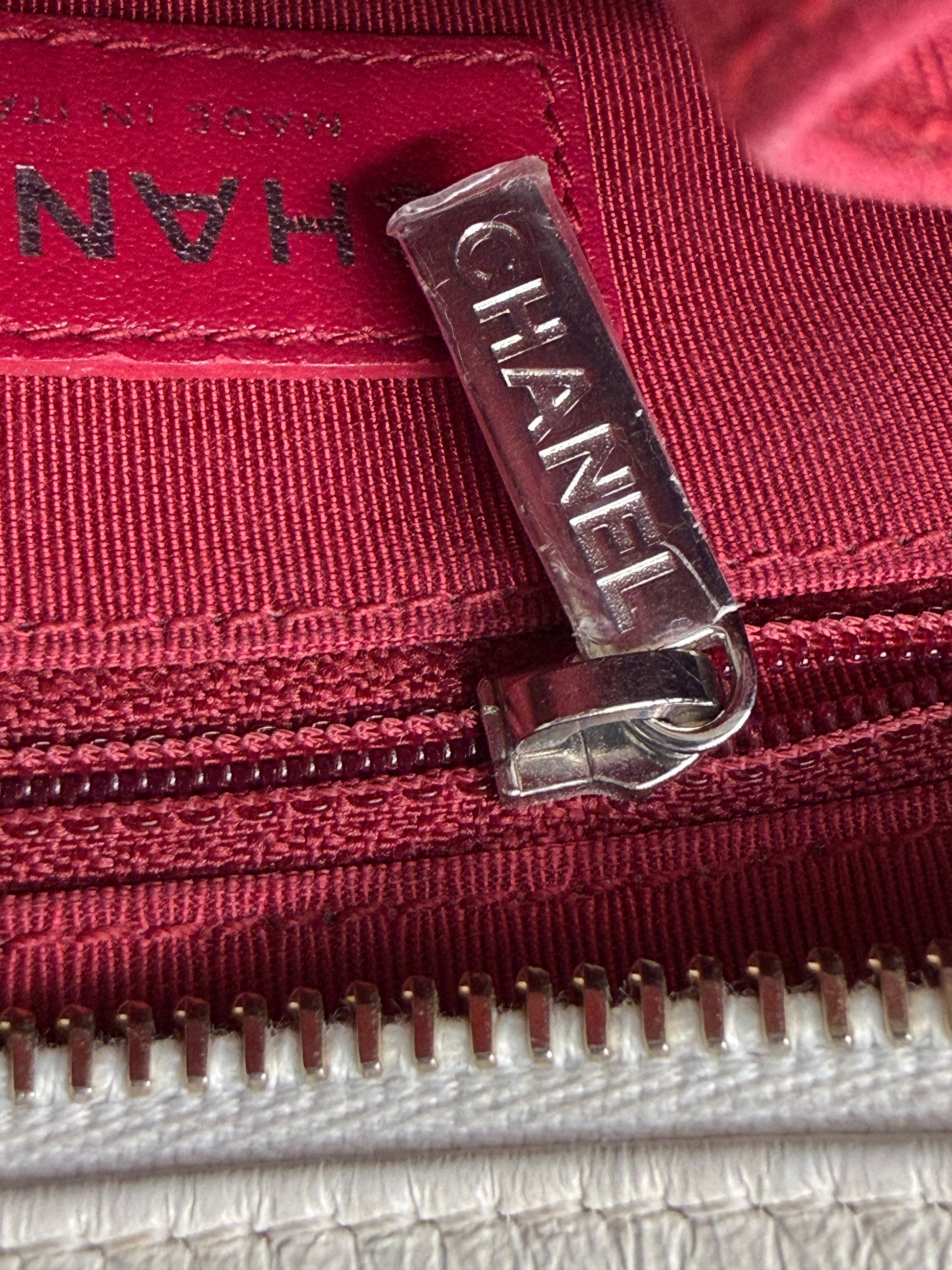 Reißverschlussdetail mit CHANEL-Logo innen in der CHANEL Gabrielle small weiß/schwarz Designer Handtasche.
